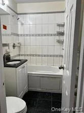 Full bathroom featuring toilet, tile patterned flooring, tiled shower / bath combo, and vanity Full bathroom featuring toilet, tile patterned flooring, tiled shower / bath combo, and vanity