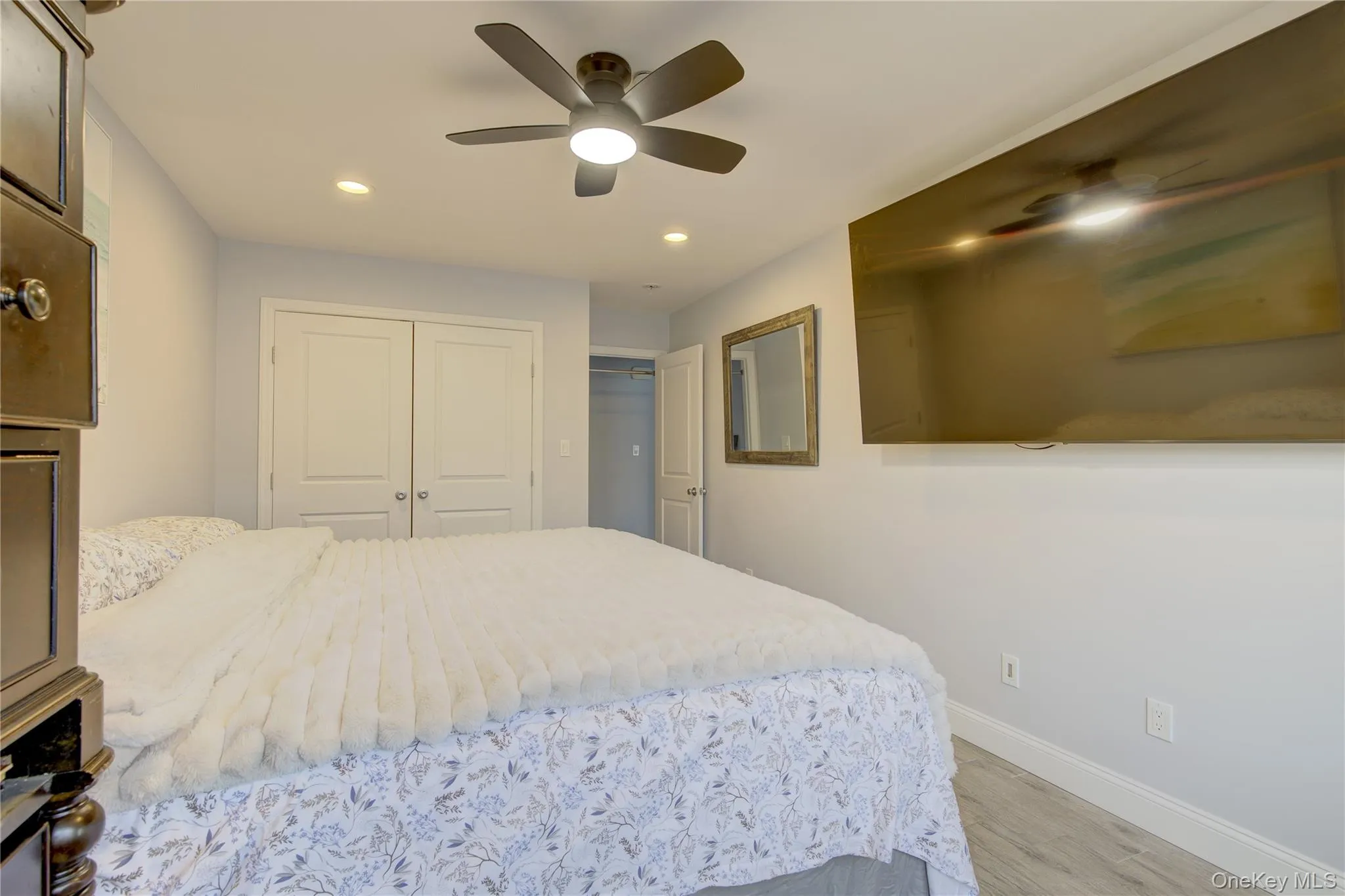 Bedroom featuring light wood finished floors, recessed lighting, a ceiling fan, and a closet Bedroom featuring light wood finished floors, recessed lighting, a ceiling fan, and a closet