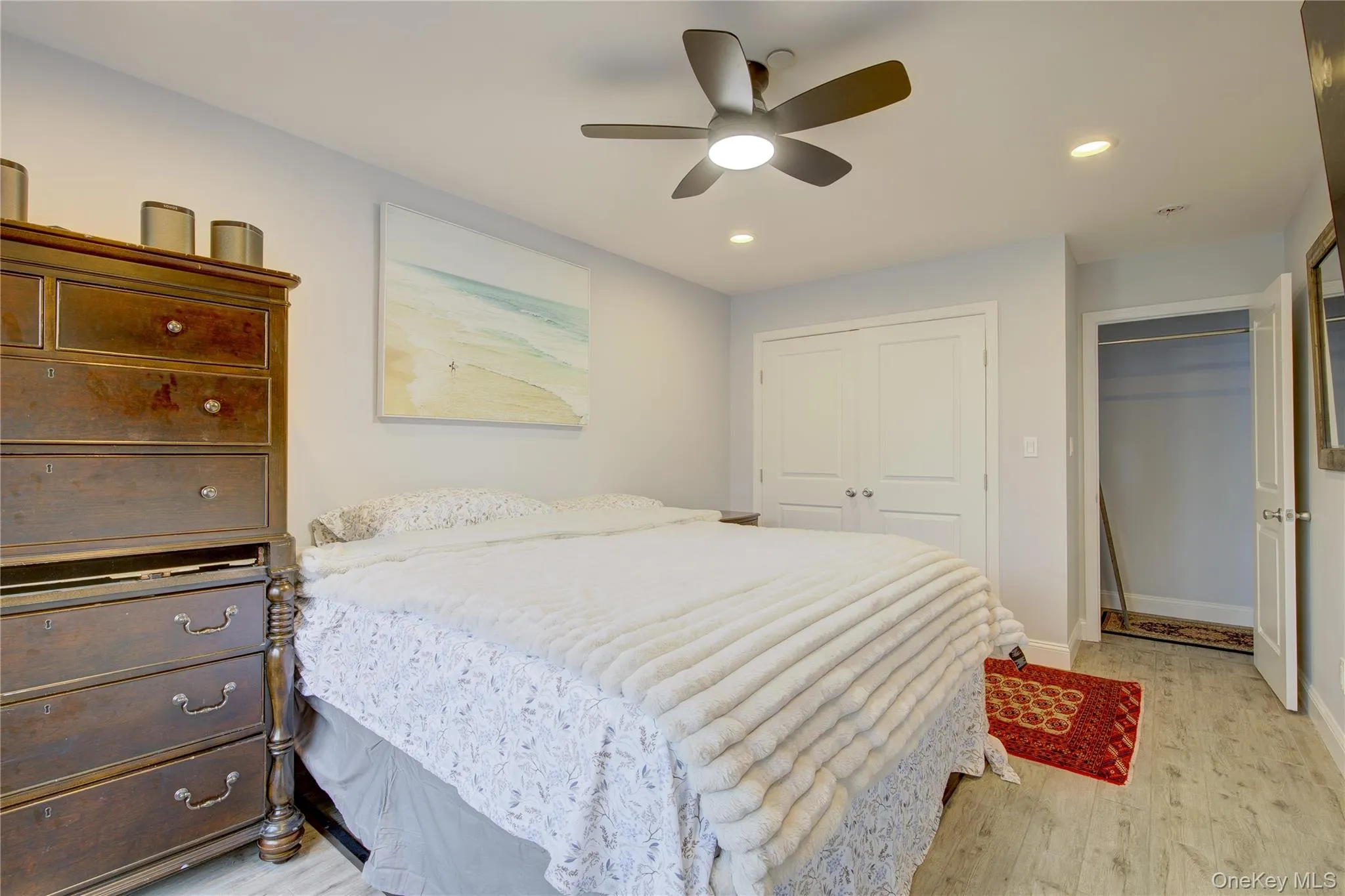 Bedroom featuring light wood-style floors, a ceiling fan, recessed lighting, and a closet Bedroom featuring light wood-style floors, a ceiling fan, recessed lighting, and a closet