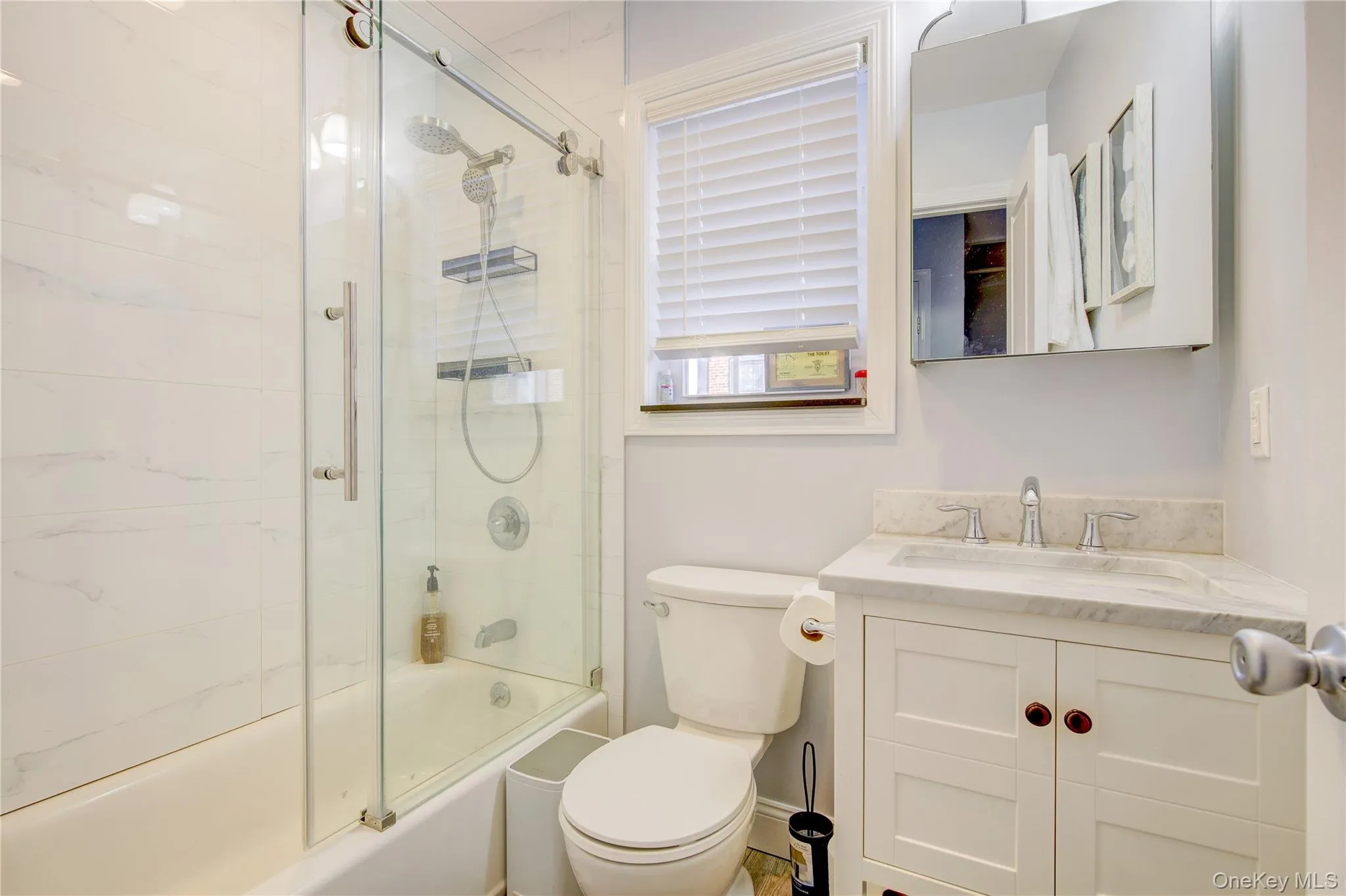 Full bathroom featuring bath / shower combo with glass door and vanity Full bathroom featuring bath / shower combo with glass door and vanity
