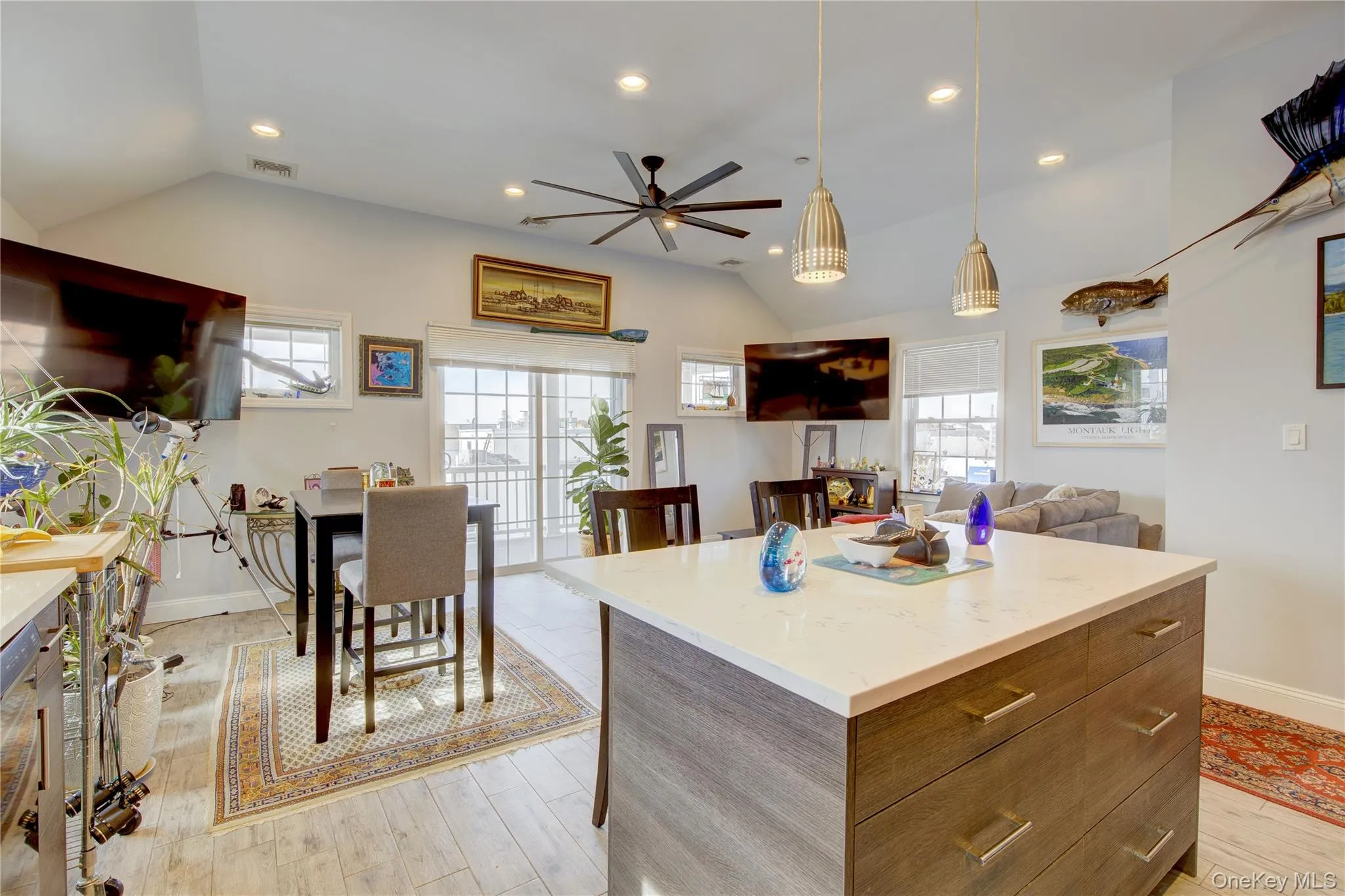 Kitchen with a center island, lofted ceiling, modern cabinets, recessed lighting, and hanging light fixtures Kitchen with a center island, lofted ceiling, modern cabinets, recessed lighting, and hanging light fixtures