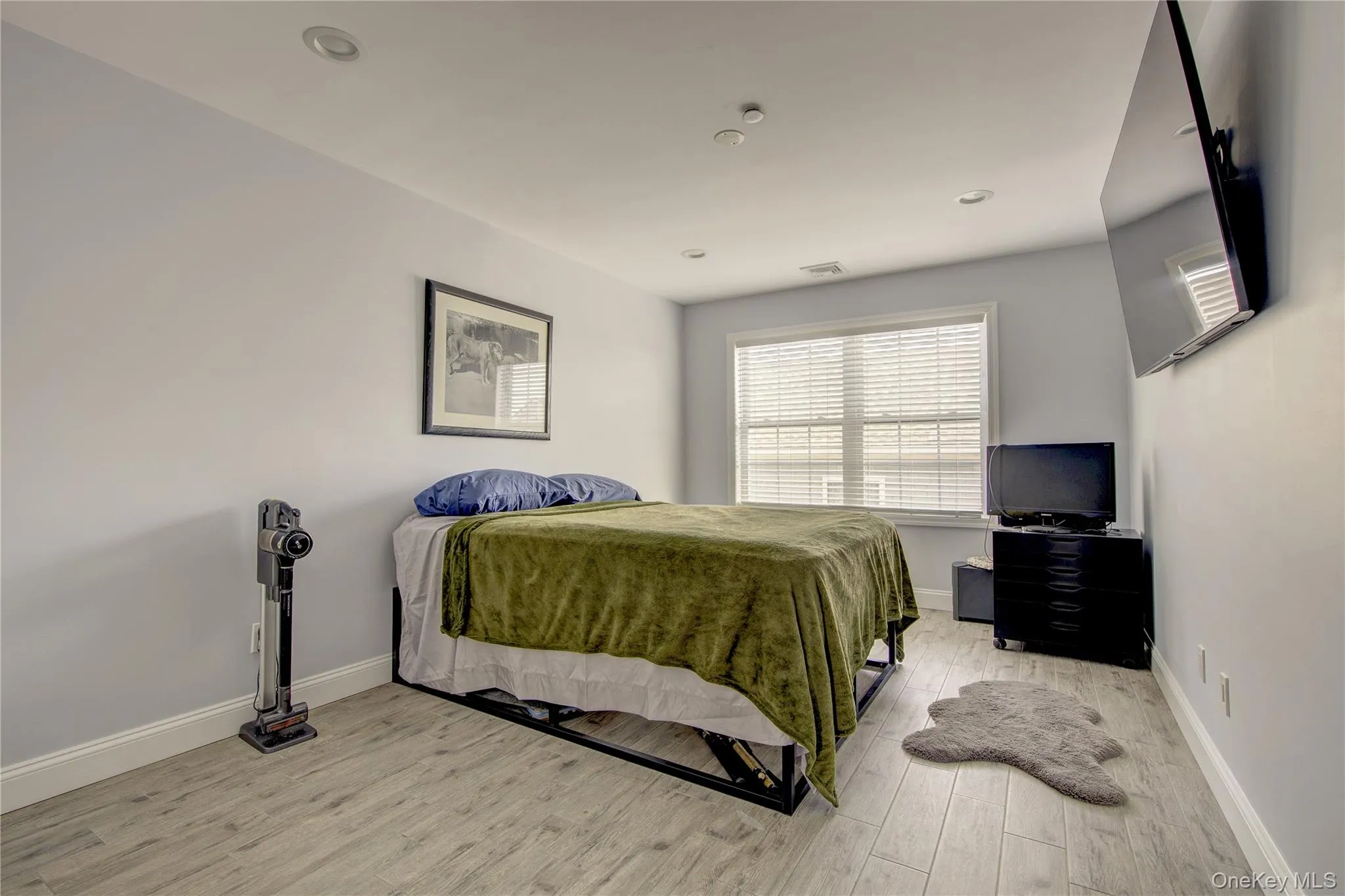 Bedroom with light wood-style floors and recessed lighting Bedroom with light wood-style floors and recessed lighting