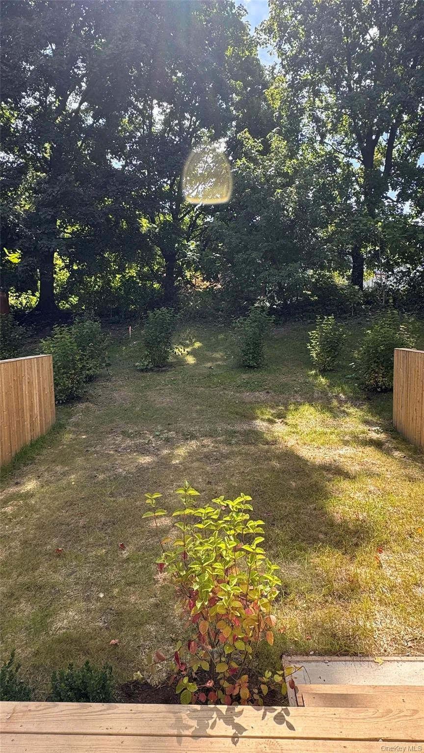 Expansive backyard featuring a grass lawn, mature trees, and privacy fencing Expansive backyard featuring a grass lawn, mature trees, and privacy fencing
