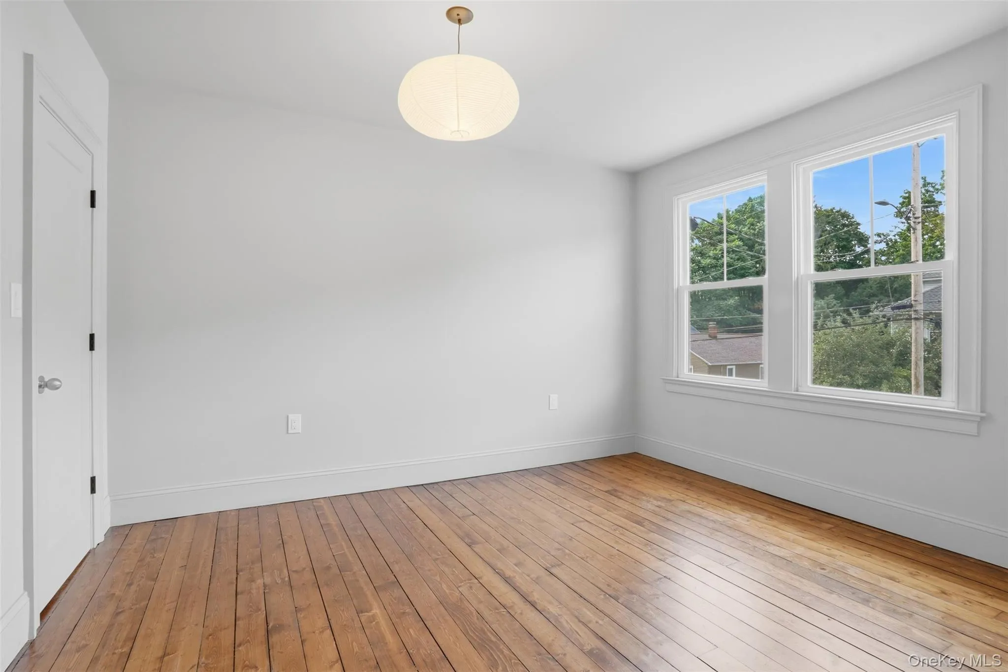 Hardwood flooring, two windows, recessed lighting, white walls, and a white interior door Hardwood flooring, two windows, recessed lighting, white walls, and a white interior door