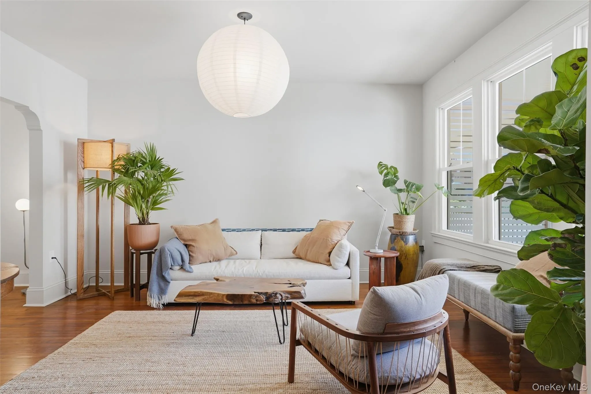 Hardwood flooring, arched doorway, large windows, ceiling-mounted light fixture, light gray wall color Hardwood flooring, arched doorway, large windows, ceiling-mounted light fixture, light gray wall color