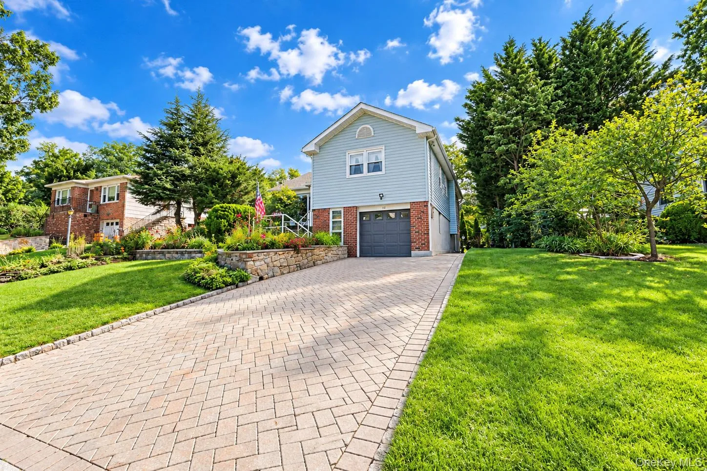 Two-story exterior with light blue siding and brick accents Two-story exterior with light blue siding and brick accents