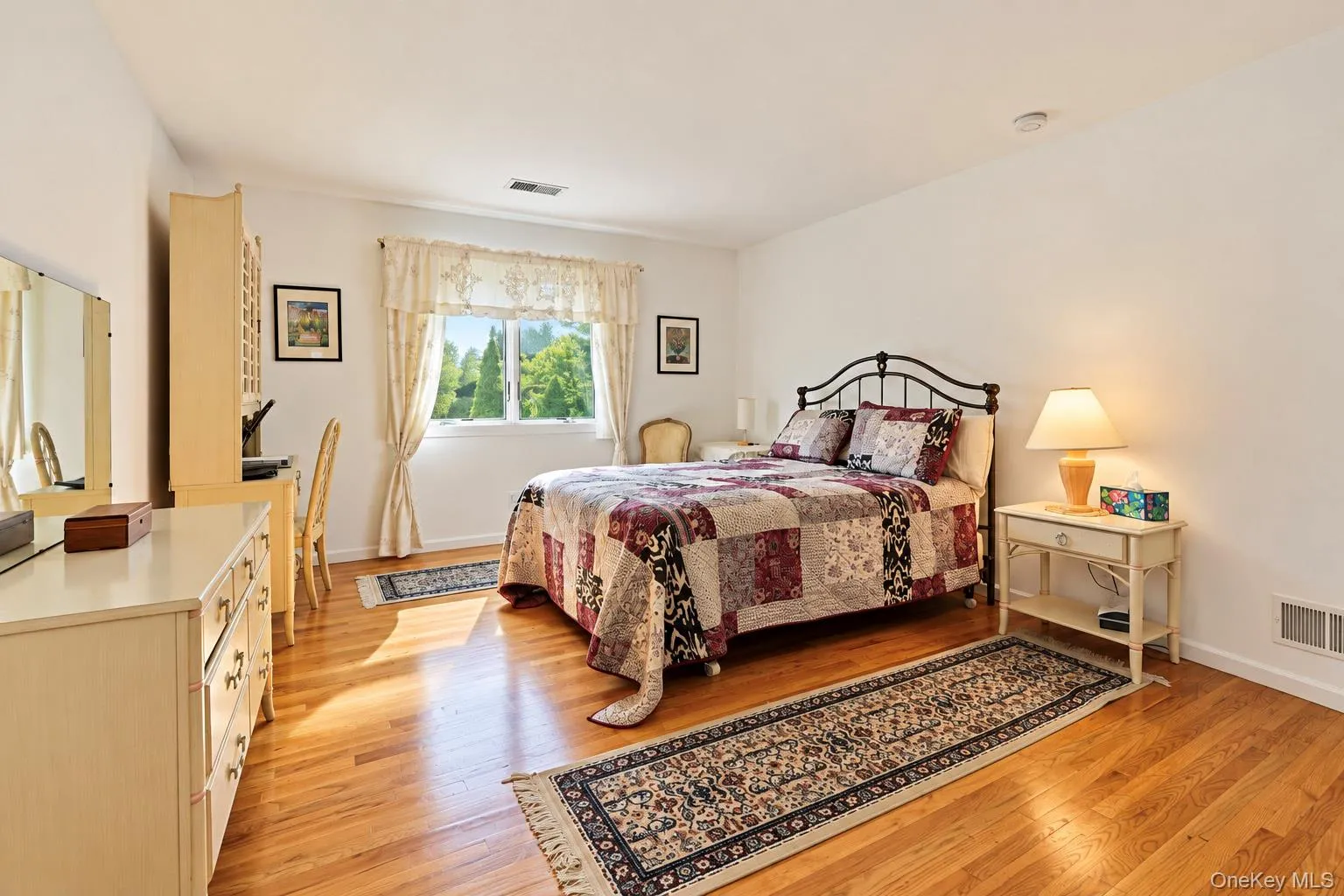 Hardwood flooring, white walls, and a large window with white trim Hardwood flooring, white walls, and a large window with white trim