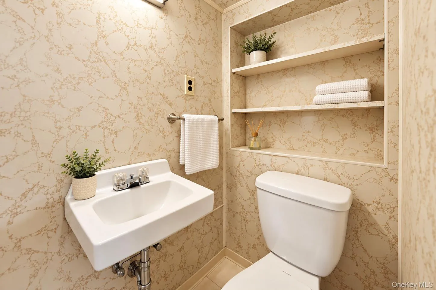 Pedestal sink, wall-mounted faucet, integrated wall shelving, wall-mounted towel bar, and a standard toilet Pedestal sink, wall-mounted faucet, integrated wall shelving, wall-mounted towel bar, and a standard toilet