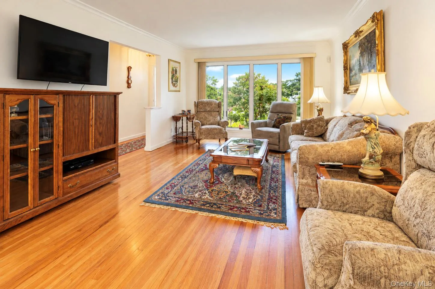 Hardwood flooring throughout, large picture windows, and a built-in wood-finish media console Hardwood flooring throughout, large picture windows, and a built-in wood-finish media console