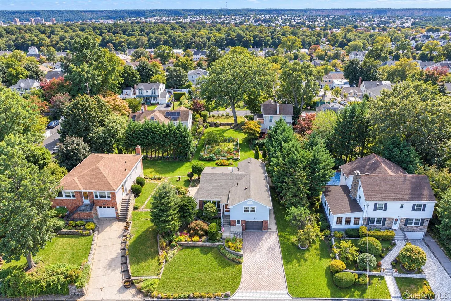 Aerial perspective showcasing multiple properties amidst mature trees and lush landscaping Aerial perspective showcasing multiple properties amidst mature trees and lush landscaping