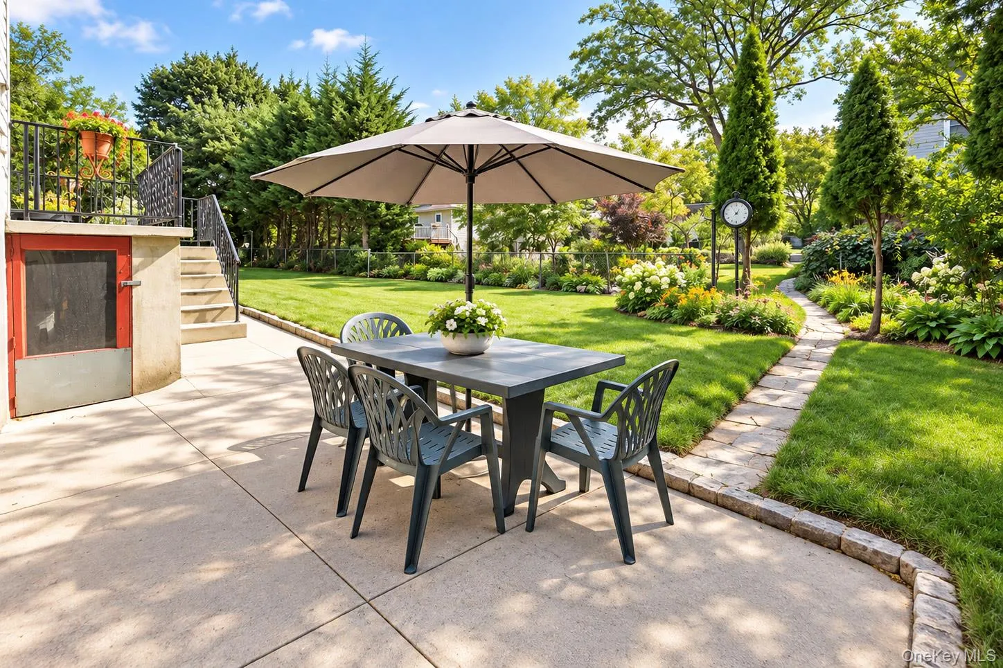 Expansive backyard featuring a concrete patio, stone walkway, lush lawn, and mature landscaping Expansive backyard featuring a concrete patio, stone walkway, lush lawn, and mature landscaping