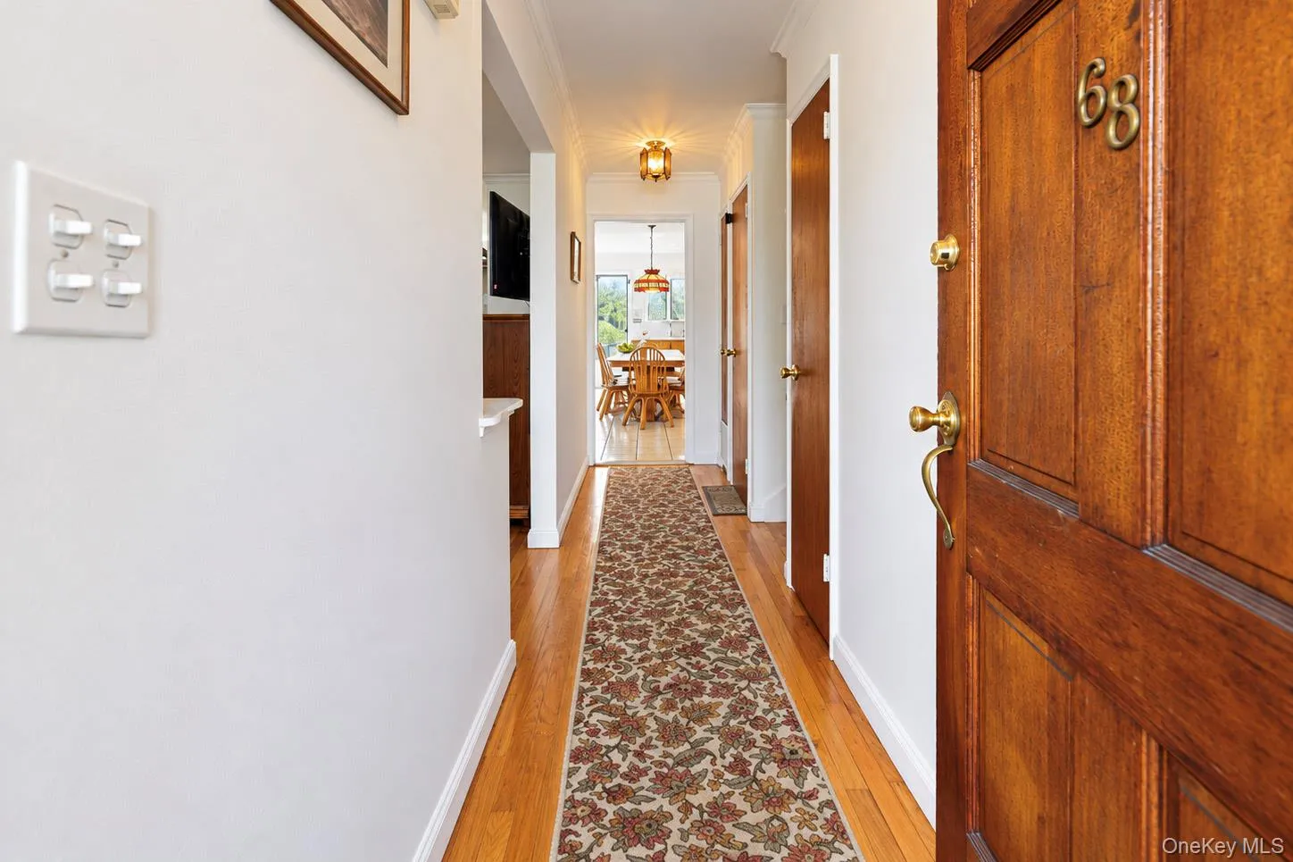 Wood-paneled entry door with brass hardware and numerals Wood-paneled entry door with brass hardware and numerals