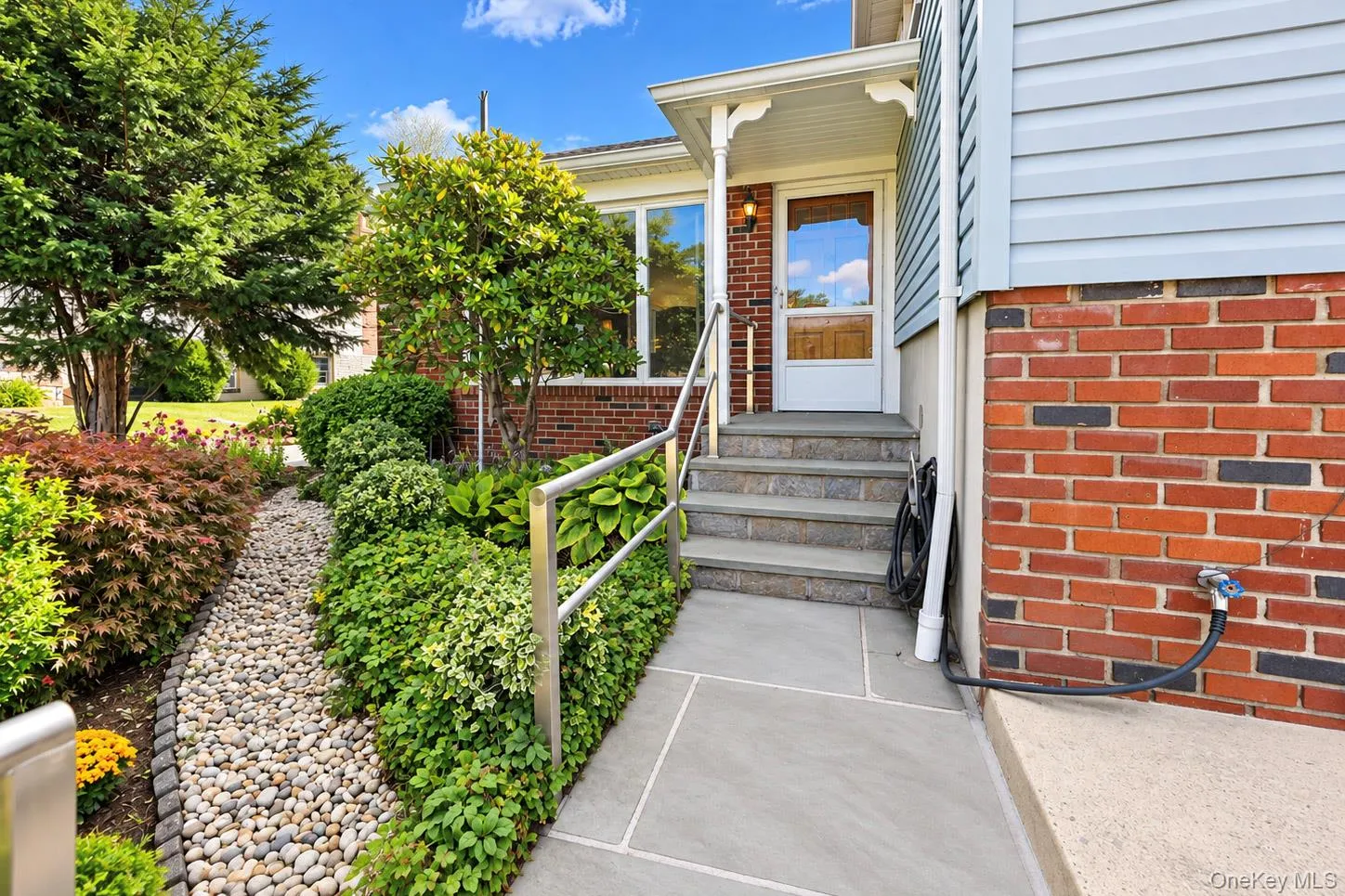 Entryway with stone steps, a white storm door, and a covered porch Entryway with stone steps, a white storm door, and a covered porch