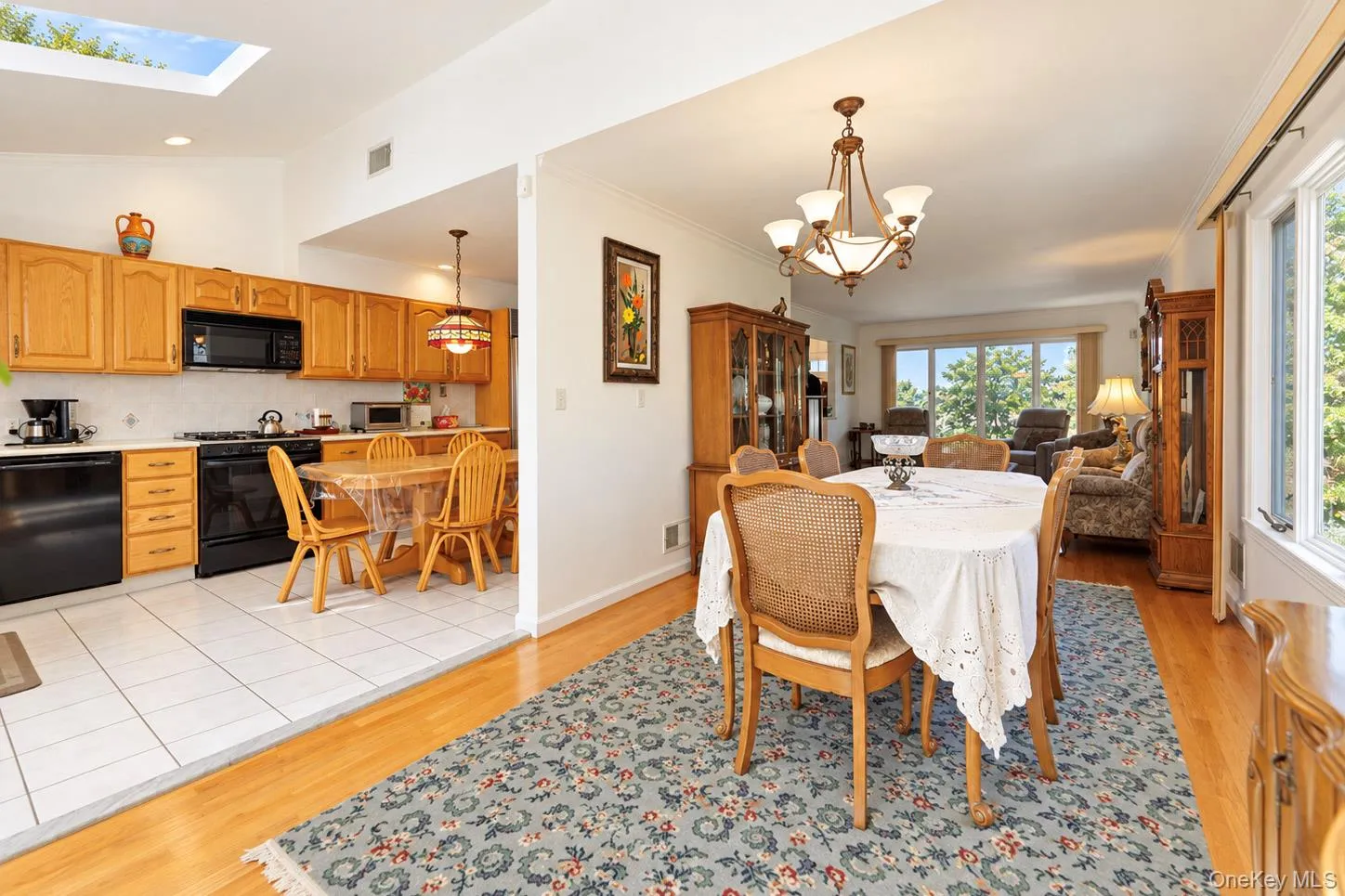 Dining area with wood-finish flooring and a decorative chandelier Dining area with wood-finish flooring and a decorative chandelier