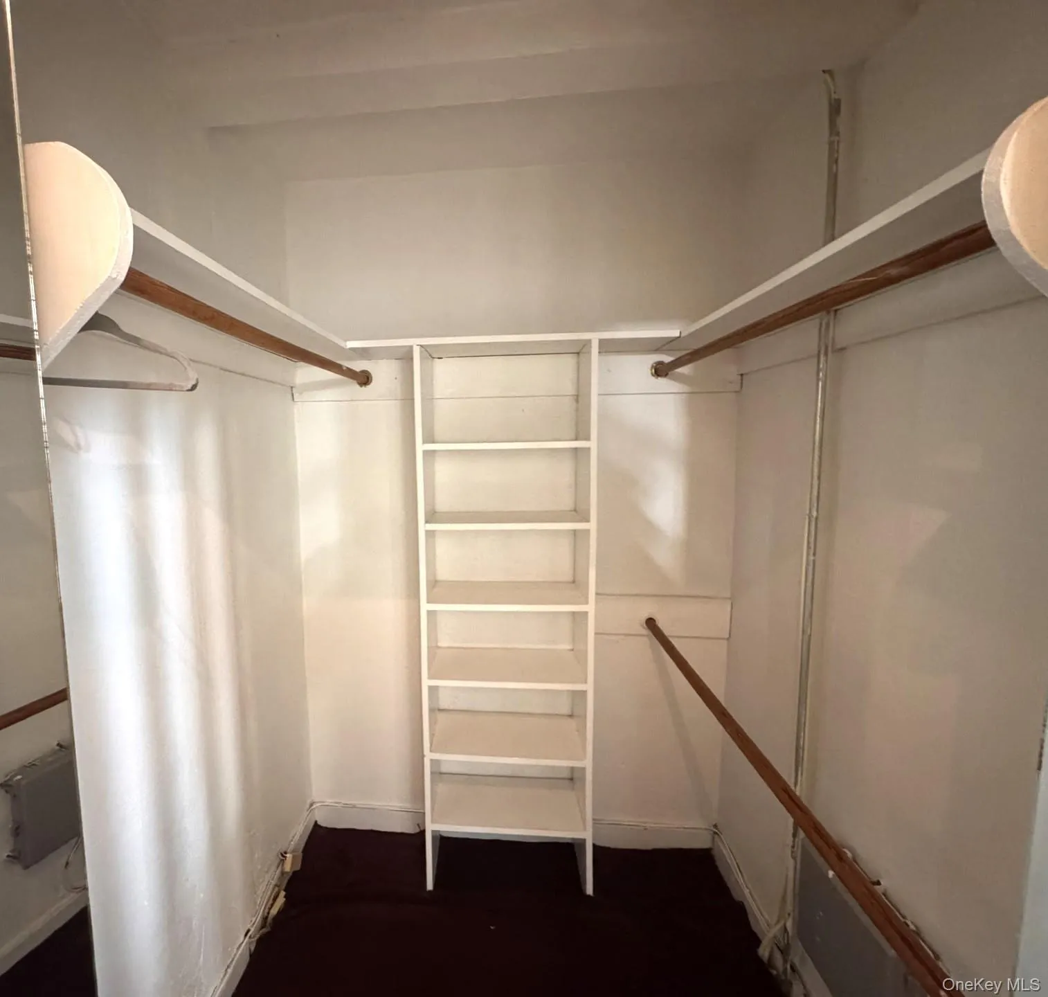 Built-in white shelving, wood-finish hanging rods. Built-in white shelving, wood-finish hanging rods.