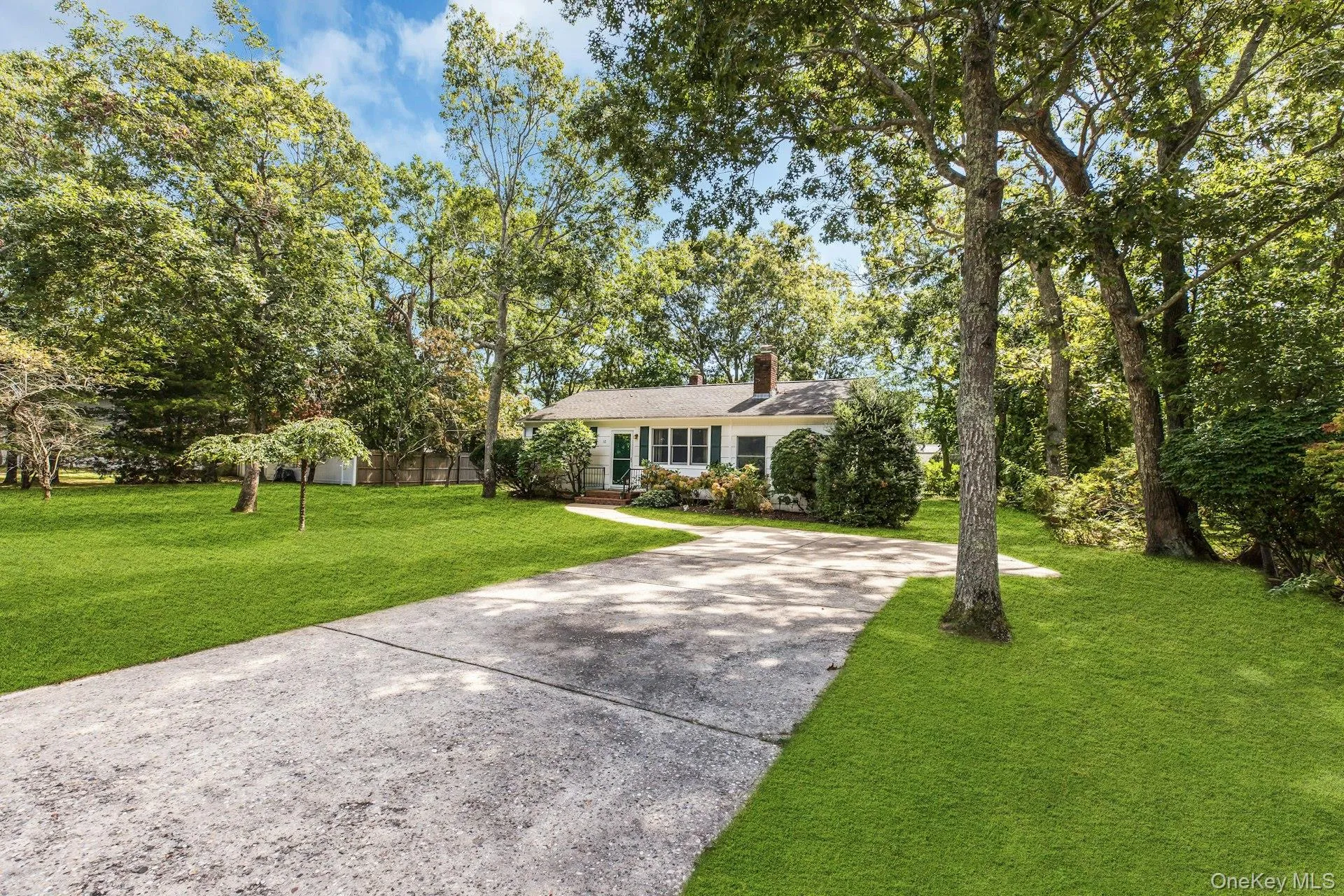 Mature landscaping with towering shade trees frames this single-story residence, set on expansive grounds with a manicured lawn Mature landscaping with towering shade trees frames this single-story residence, set on expansive grounds with a manicured lawn