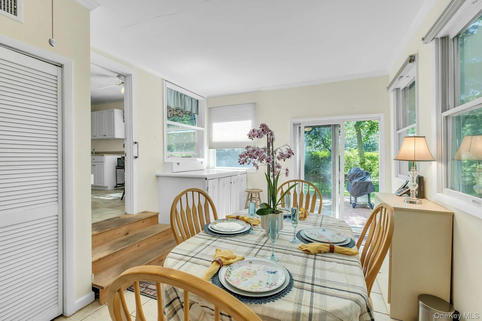 Bright dining area with wood-finish flooring, a glass-top table, and natural light from multiple windows and glass doors Bright dining area with wood-finish flooring, a glass-top table, and natural light from multiple windows and glass doors