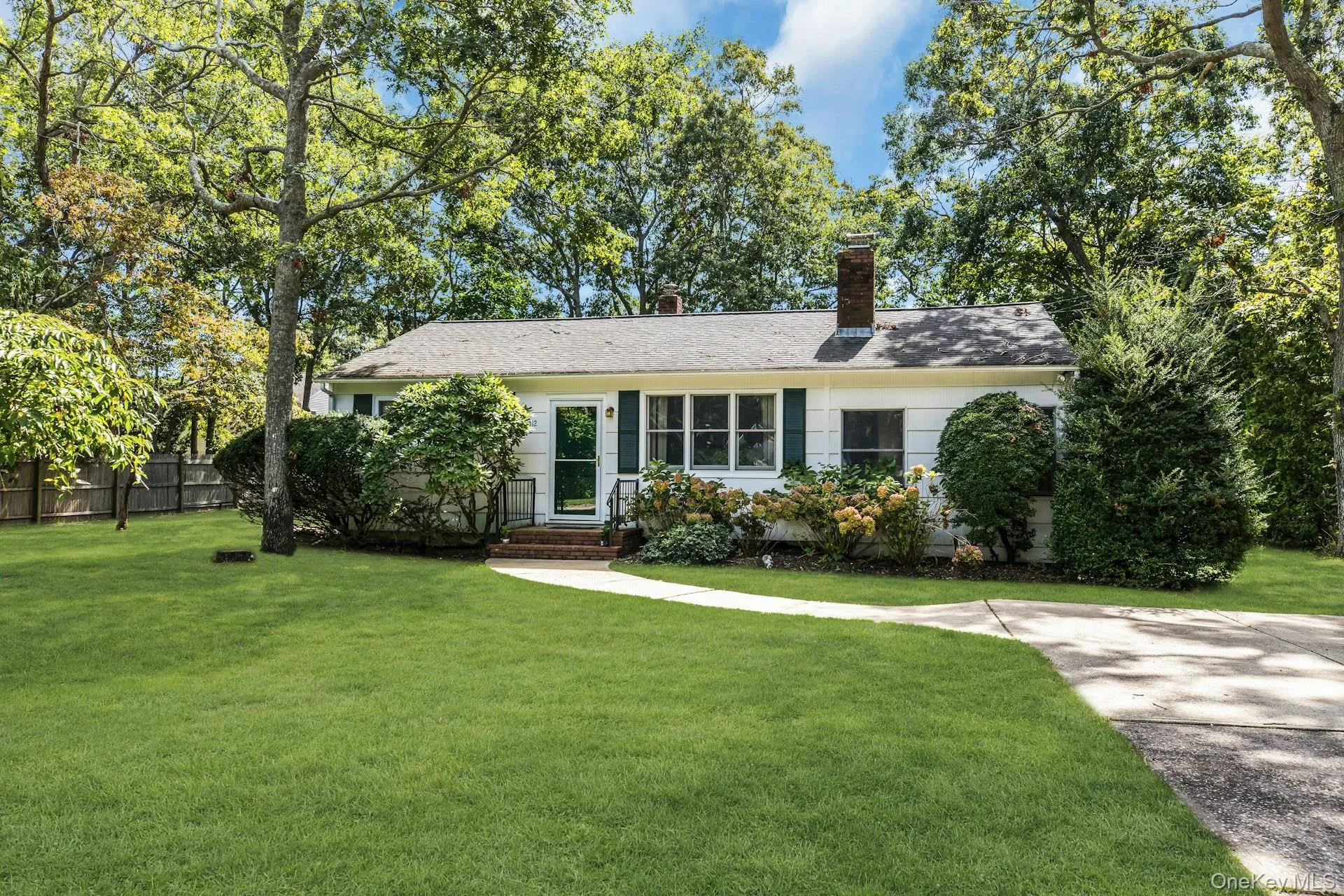 Ranch-style exterior with white siding, dark green shutters, and a gray shingle roof Ranch-style exterior with white siding, dark green shutters, and a gray shingle roof