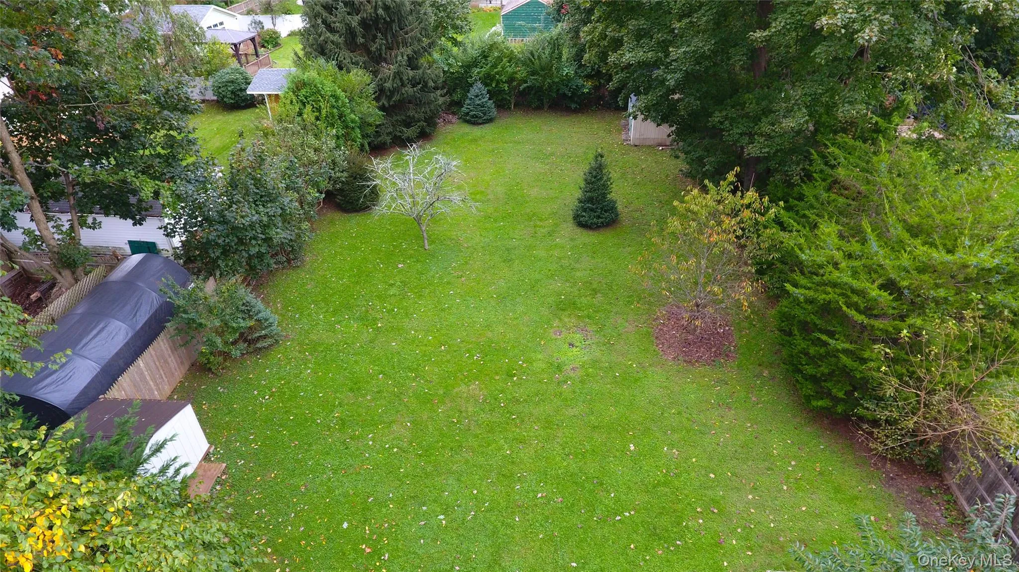 Aerial View of the spacious yard and the portable carport. Aerial View of the spacious yard and the portable carport.