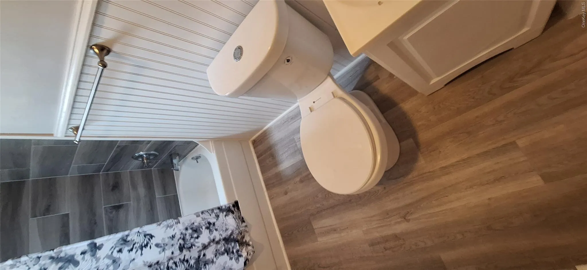 Bathroom with toilet, shower / tub combo, and vinyl plank floors Bathroom with toilet, shower / tub combo, and vinyl plank floors