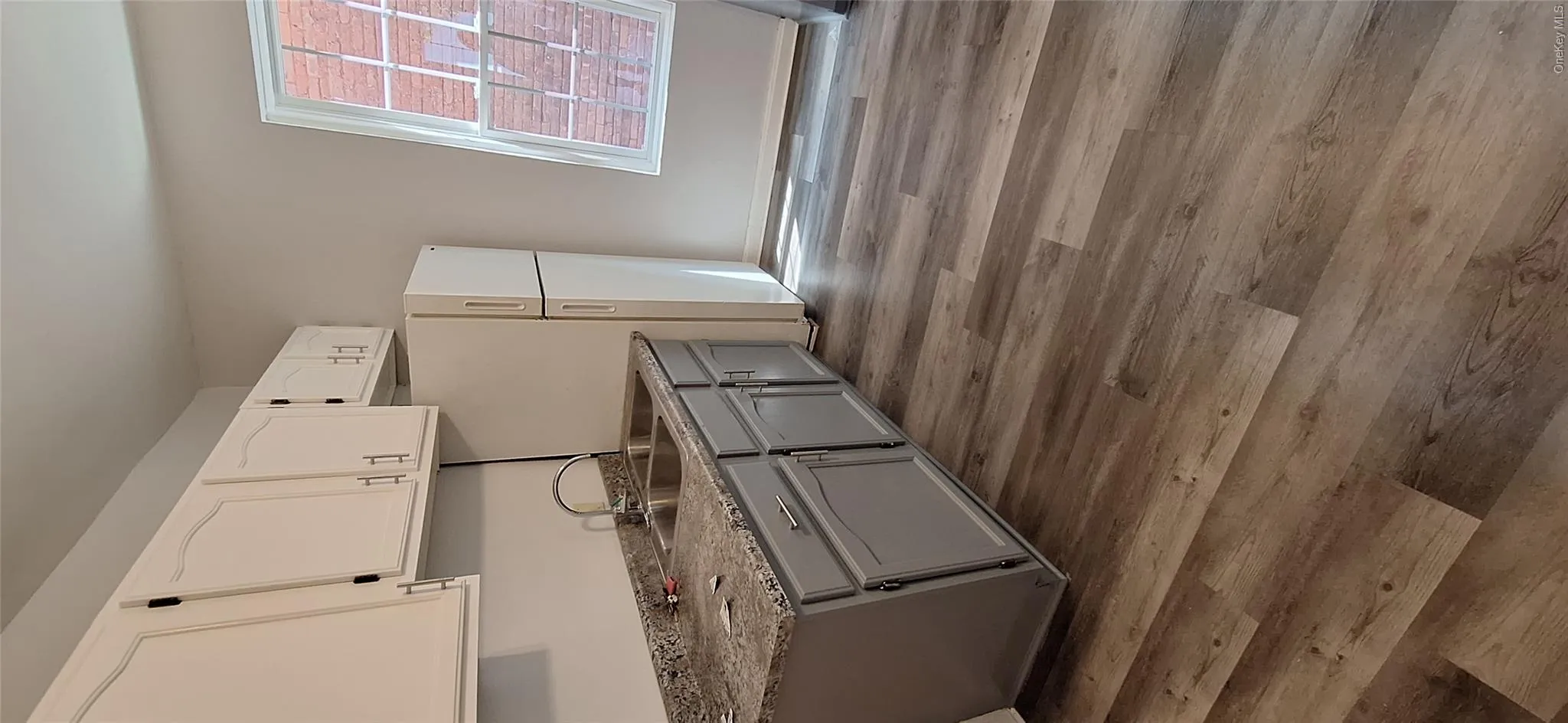 Kitchen featuring baseboards, white cabinets, dark vinyl plank flooring, gray cabinets Kitchen featuring baseboards, white cabinets, dark vinyl plank flooring, gray cabinets