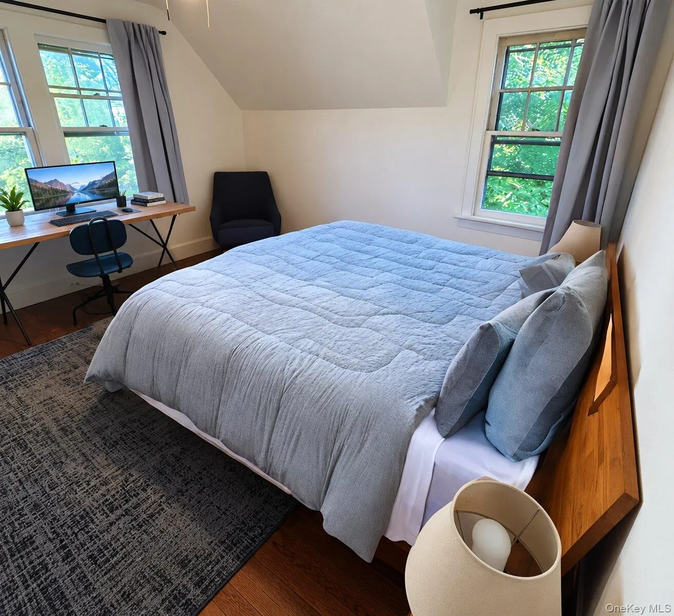 Virtually Staged. Bedroom featuring hardwood / wood-style floors, vaulted ceiling, and multiple windows Virtually Staged. Bedroom featuring hardwood / wood-style floors, vaulted ceiling, and multiple windows