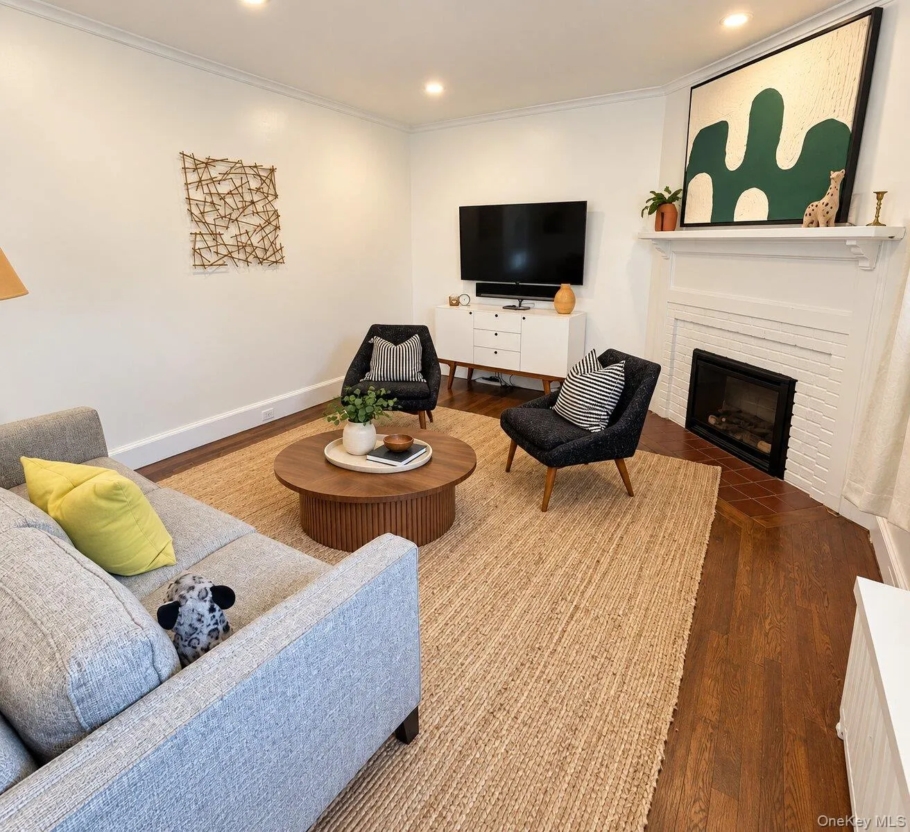 Virtually Staged. Living room featuring wood-type flooring and a brick fireplace Virtually Staged. Living room featuring wood-type flooring and a brick fireplace