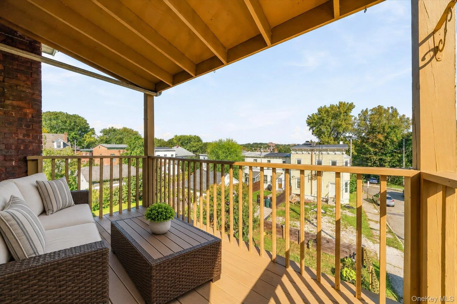 Virtually Staged Furniture. Alternate view of the covered porch showcasing the wood railing and open neighborhood views. Virtually Staged Furniture. Alternate view of the covered porch showcasing the wood railing and open neighborhood views.