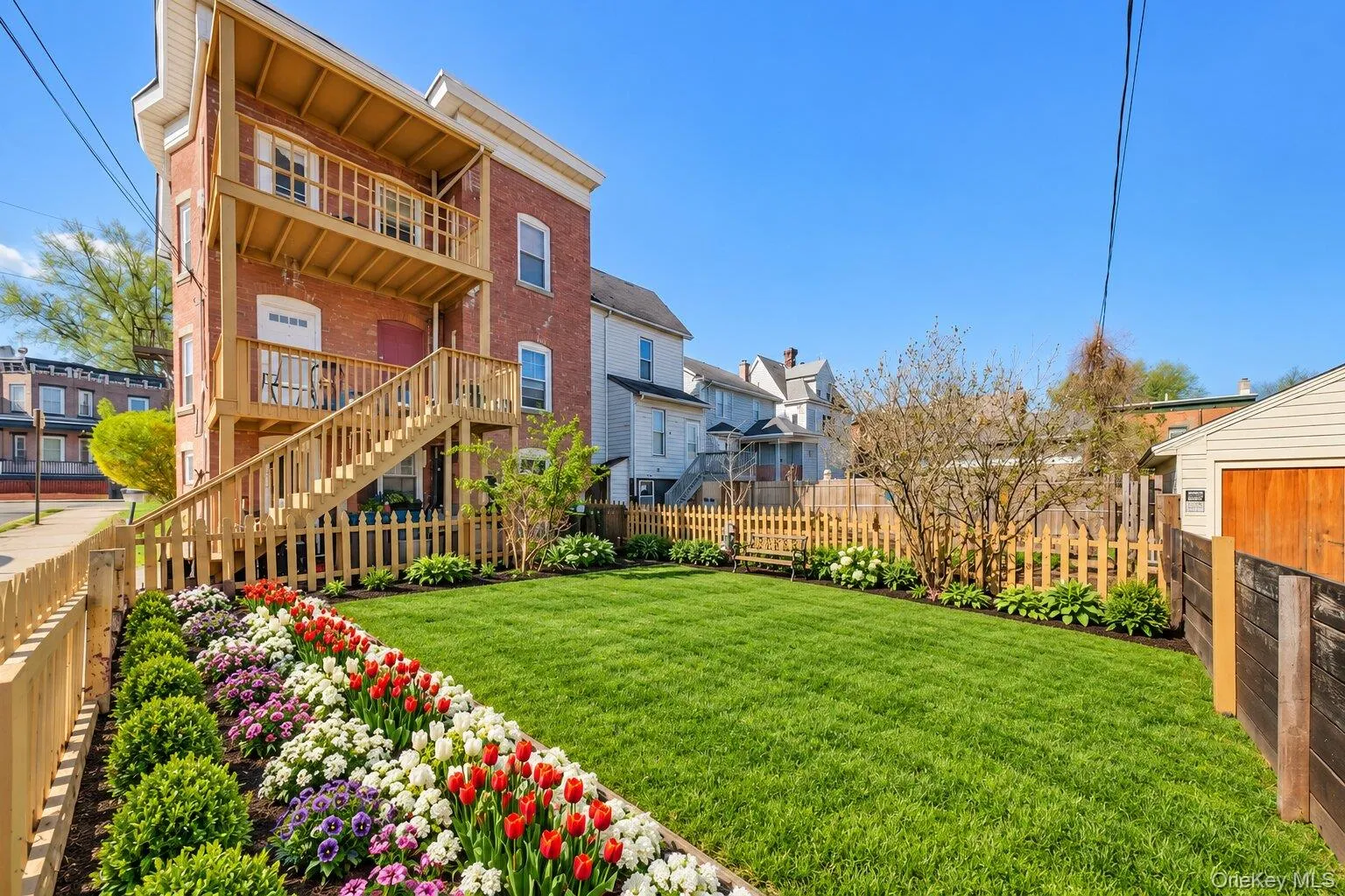 Virtually Staged Furniture. Rear exterior view of the home with multi-level porch and stair access overlooking a fenced backyard. Virtually Staged Furniture. Rear exterior view of the home with multi-level porch and stair access overlooking a fenced backyard.