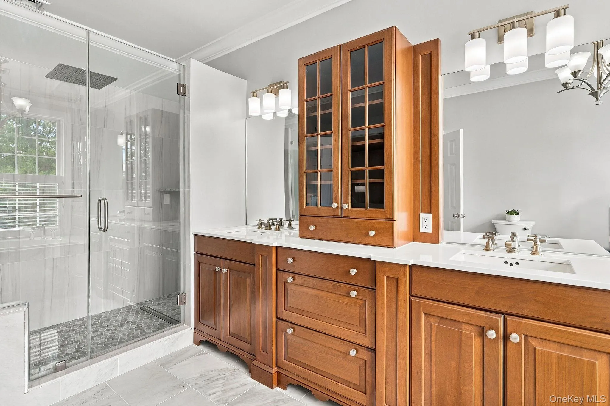Spa-inspired luxury with dual vanities, marble finishes and a glass-enclosed shower. Spa-inspired luxury with dual vanities, marble finishes and a glass-enclosed shower.