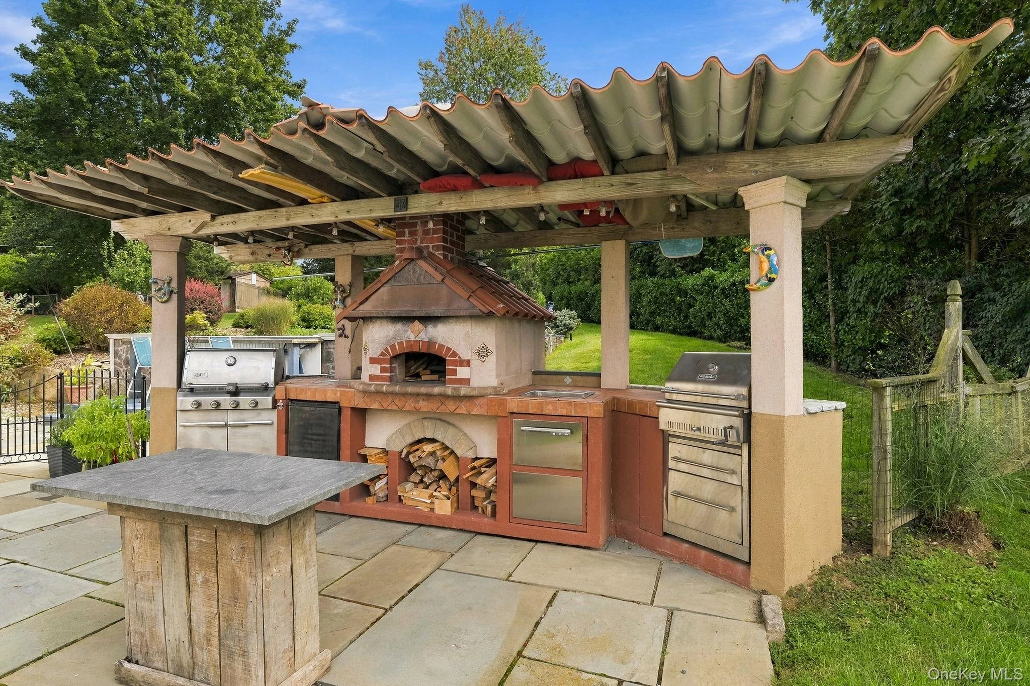 Outdoor entertaining reaches another level with a built-in grill and pizza oven. Outdoor entertaining reaches another level with a built-in grill and pizza oven.