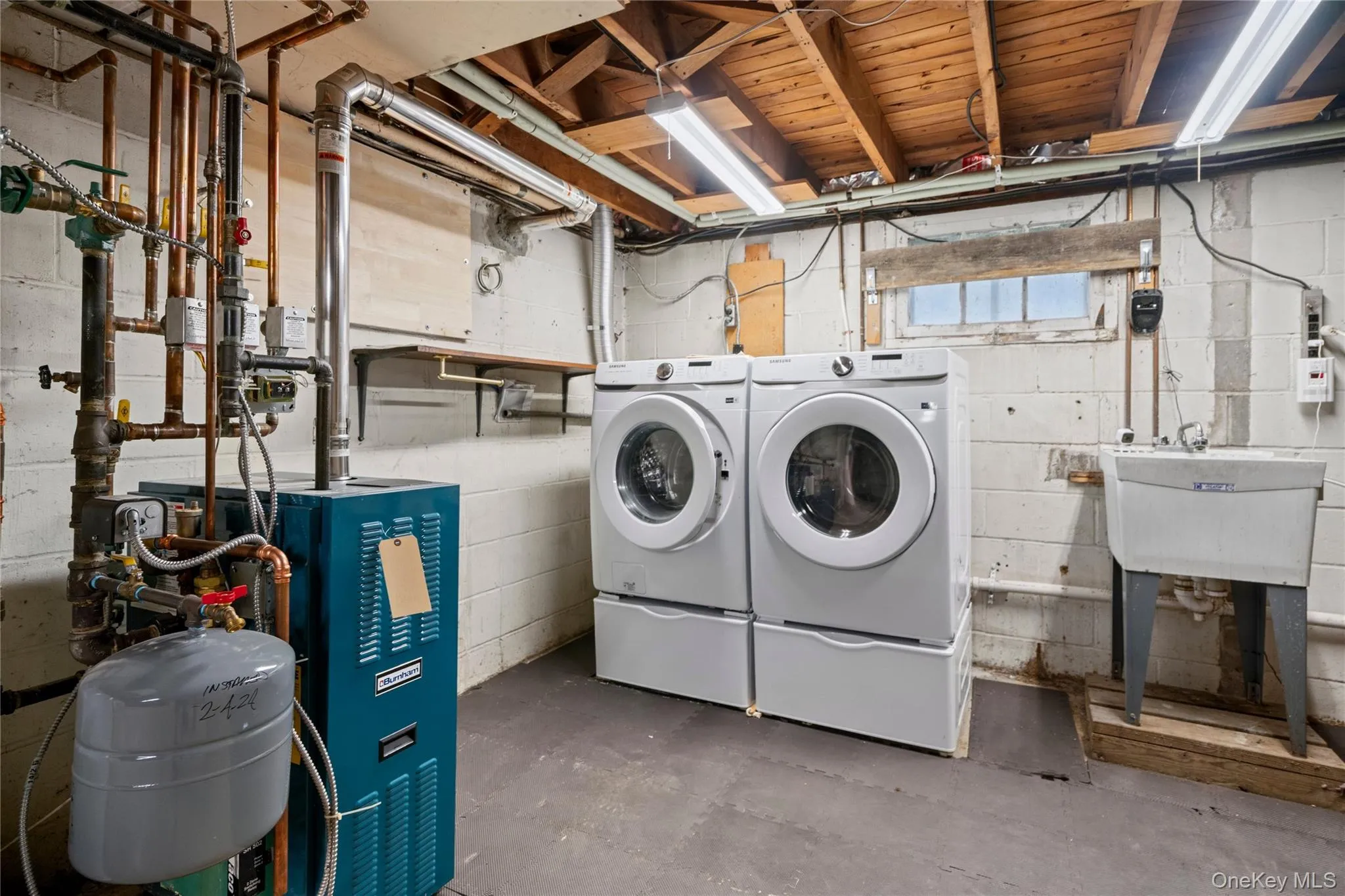 The right side of the stairs has the laundry area with newer Samsung front-load washer (2022) and a Samsung electric dryer (2023), plus a slop sink. The right side of the stairs has the laundry area with newer Samsung front-load washer (2022) and a Samsung electric dryer (2023), plus a slop sink.