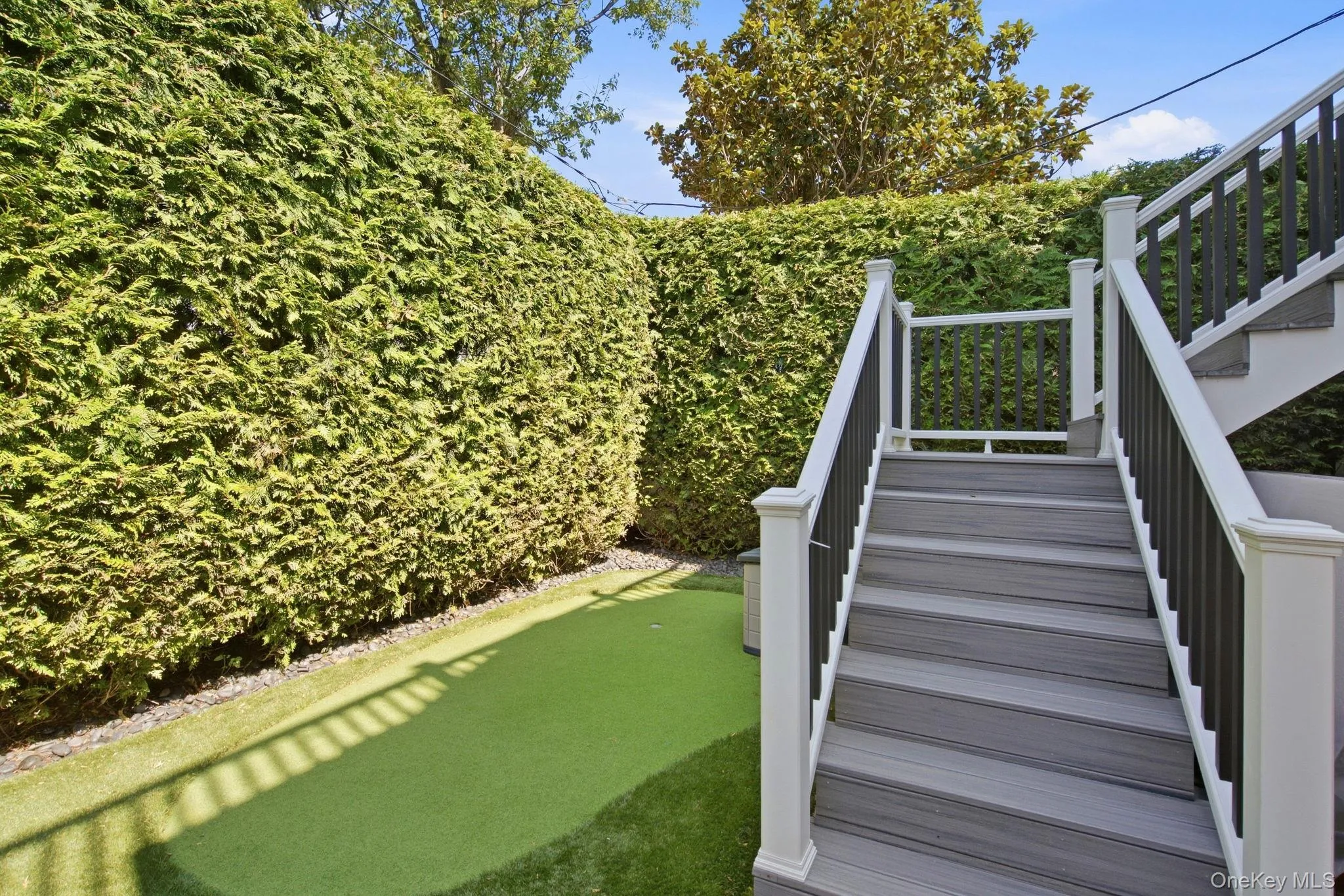 Turf lawn and putting green with stairs to primary bedroom private deck Turf lawn and putting green with stairs to primary bedroom private deck