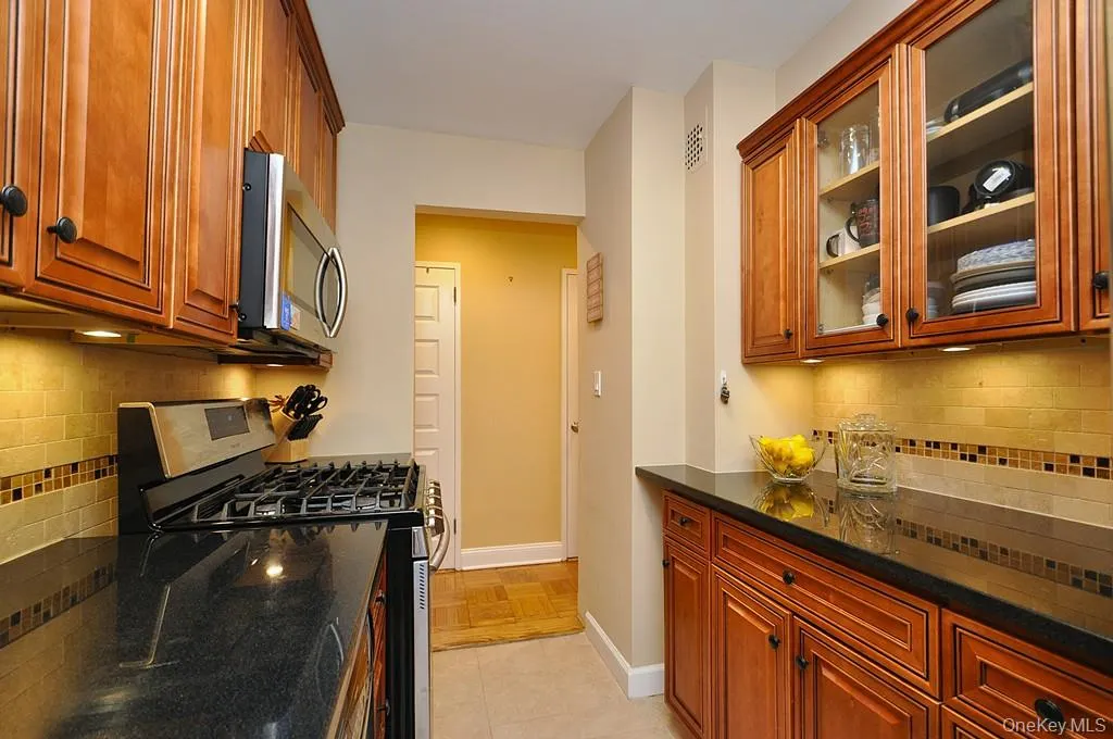 The Renovated walk thru kitchen has granite counters, stainless steal appliances and custom cabinets. The Renovated walk thru kitchen has granite counters, stainless steal appliances and custom cabinets.