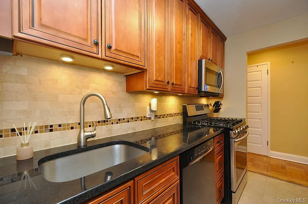 The Renovated walk thru kitchen has granite counters, stainless steal appliances and custom cabinets. The Renovated walk thru kitchen has granite counters, stainless steal appliances and custom cabinets.