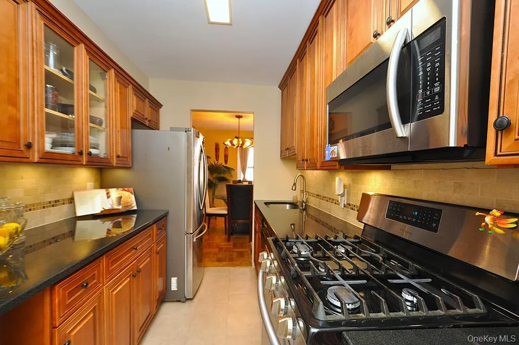 The Renovated walk thru kitchen has granite counters, stainless steal appliances and custom cabinets. The Renovated walk thru kitchen has granite counters, stainless steal appliances and custom cabinets.