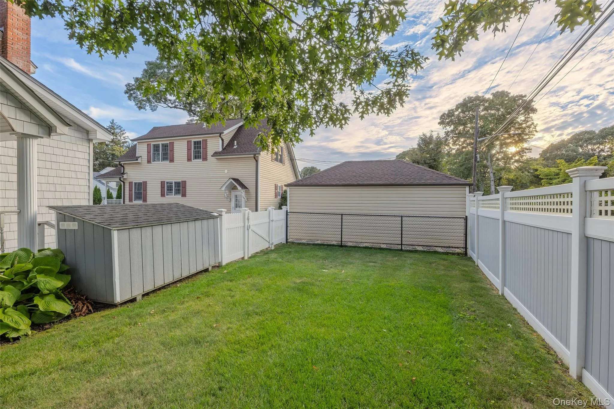 Expansive lawn area, durable vinyl fencing, and a functional storage shed with sloped roof Expansive lawn area, durable vinyl fencing, and a functional storage shed with sloped roof