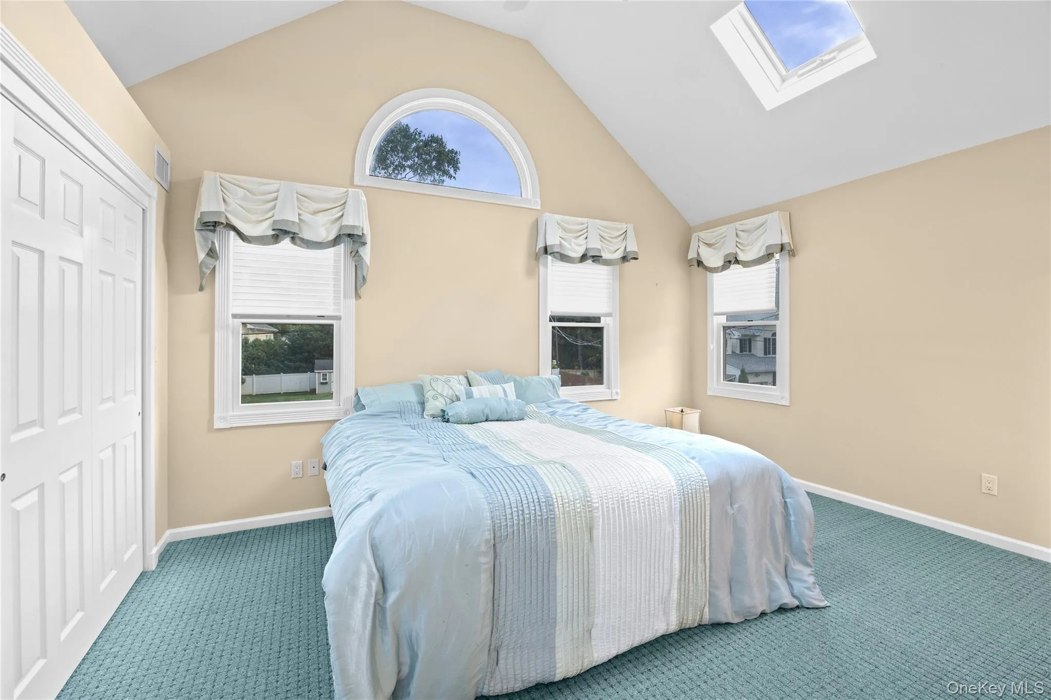 Vaulted ceiling, arched window, skylight, and wall-to-wall carpeting Vaulted ceiling, arched window, skylight, and wall-to-wall carpeting