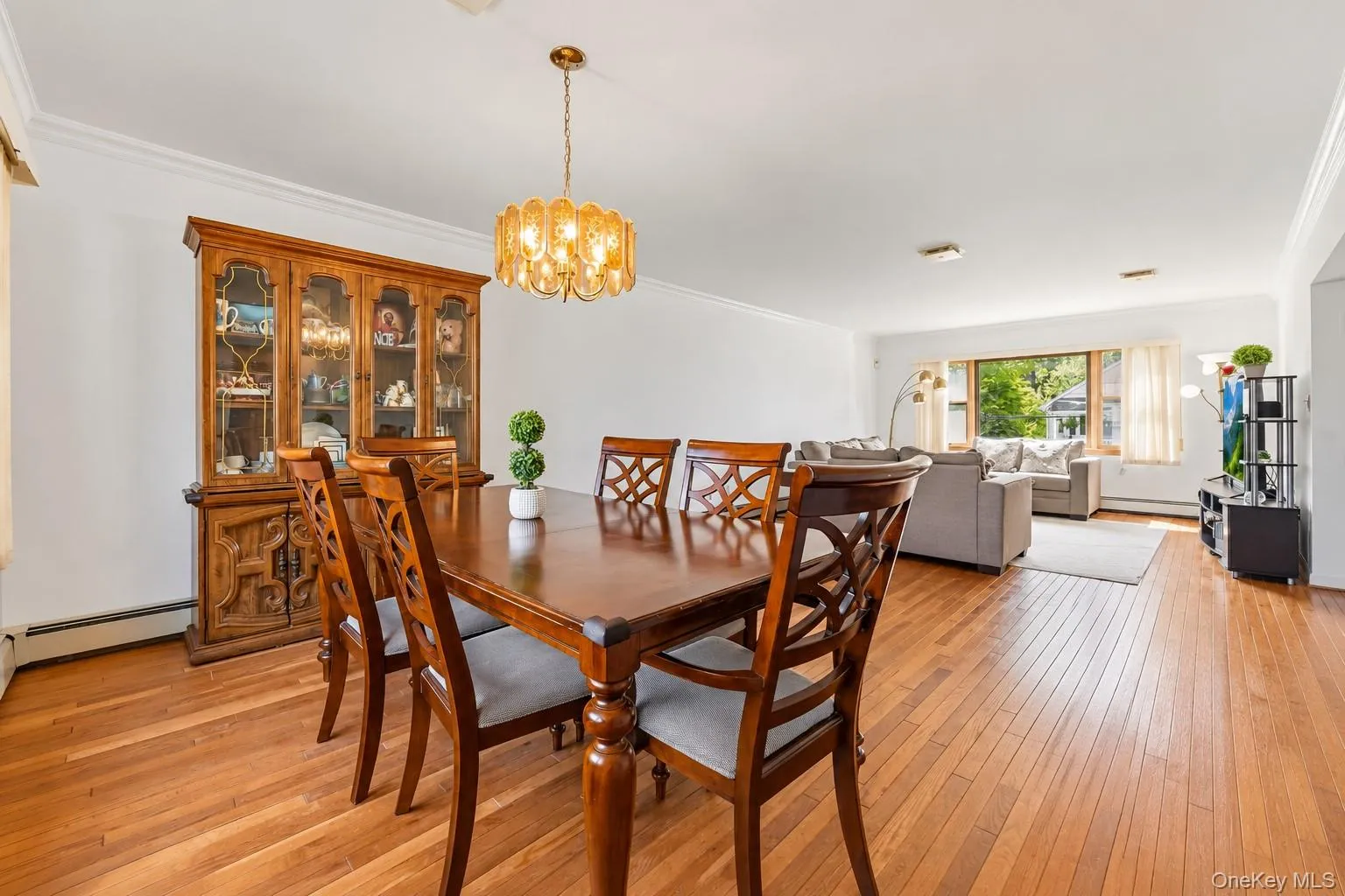 Hardwood flooring throughout, crown molding, and a decorative chandelier Hardwood flooring throughout, crown molding, and a decorative chandelier