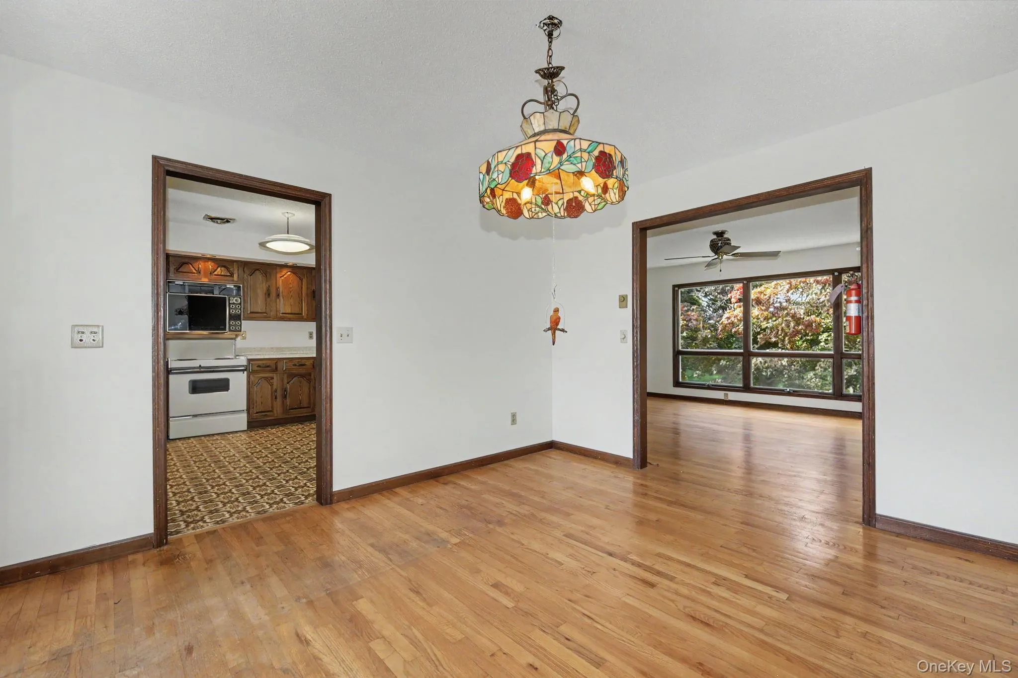 Dining room with hard wood floors leading to kitchen and living room Dining room with hard wood floors leading to kitchen and living room