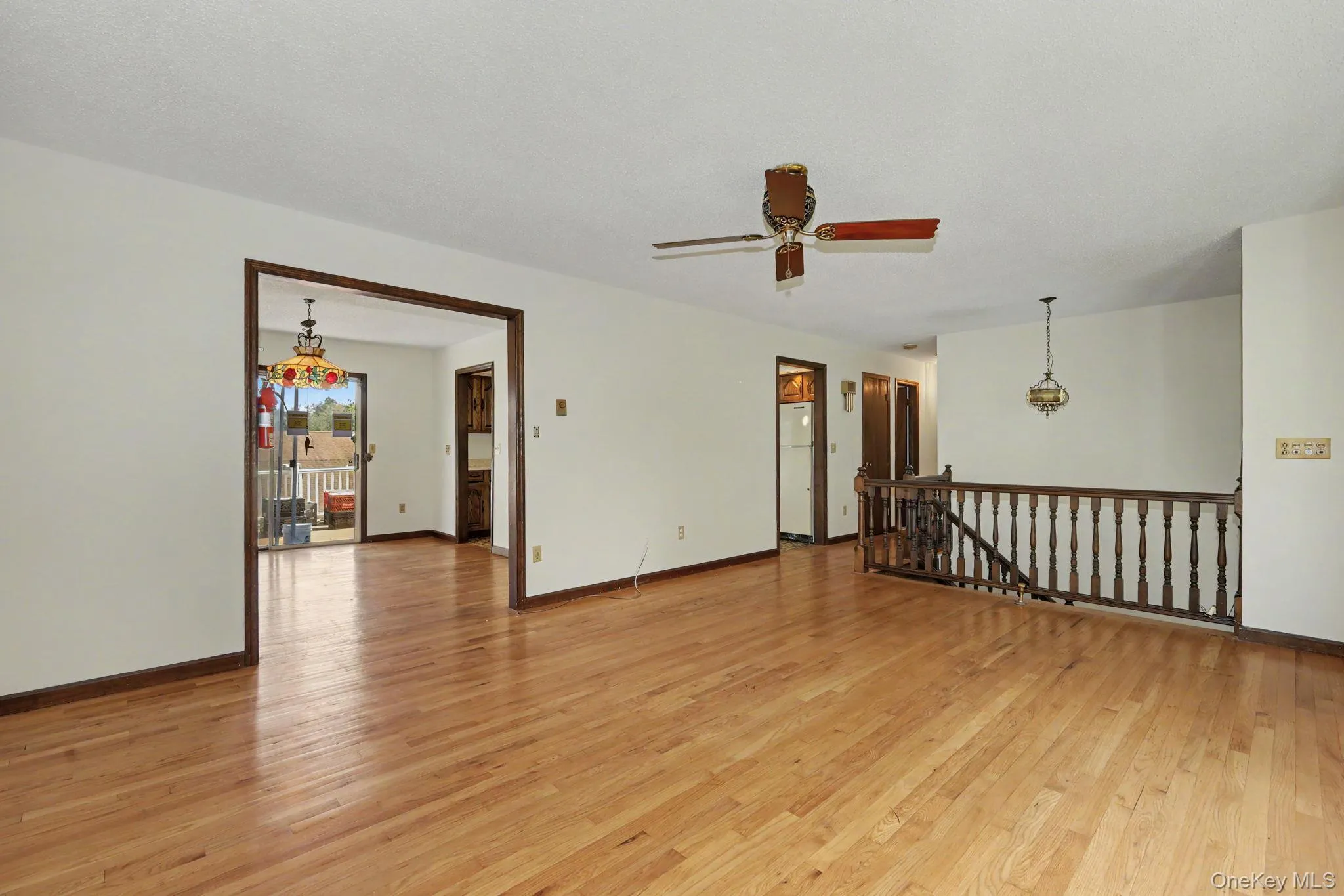 Living room with hardwood floors leading to dining room and hallway Living room with hardwood floors leading to dining room and hallway