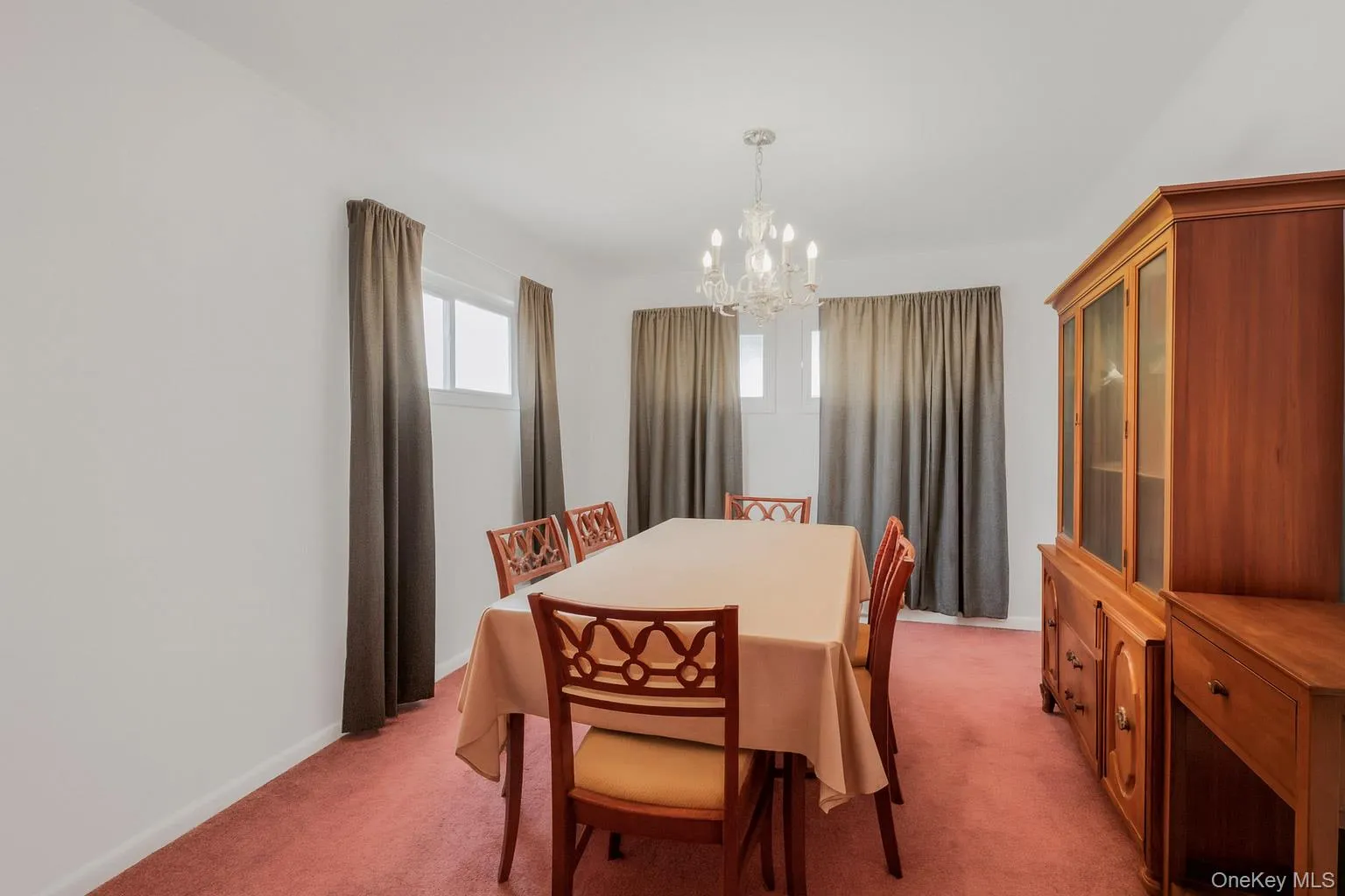 Dining area featuring light carpet and a chandelier Dining area featuring light carpet and a chandelier