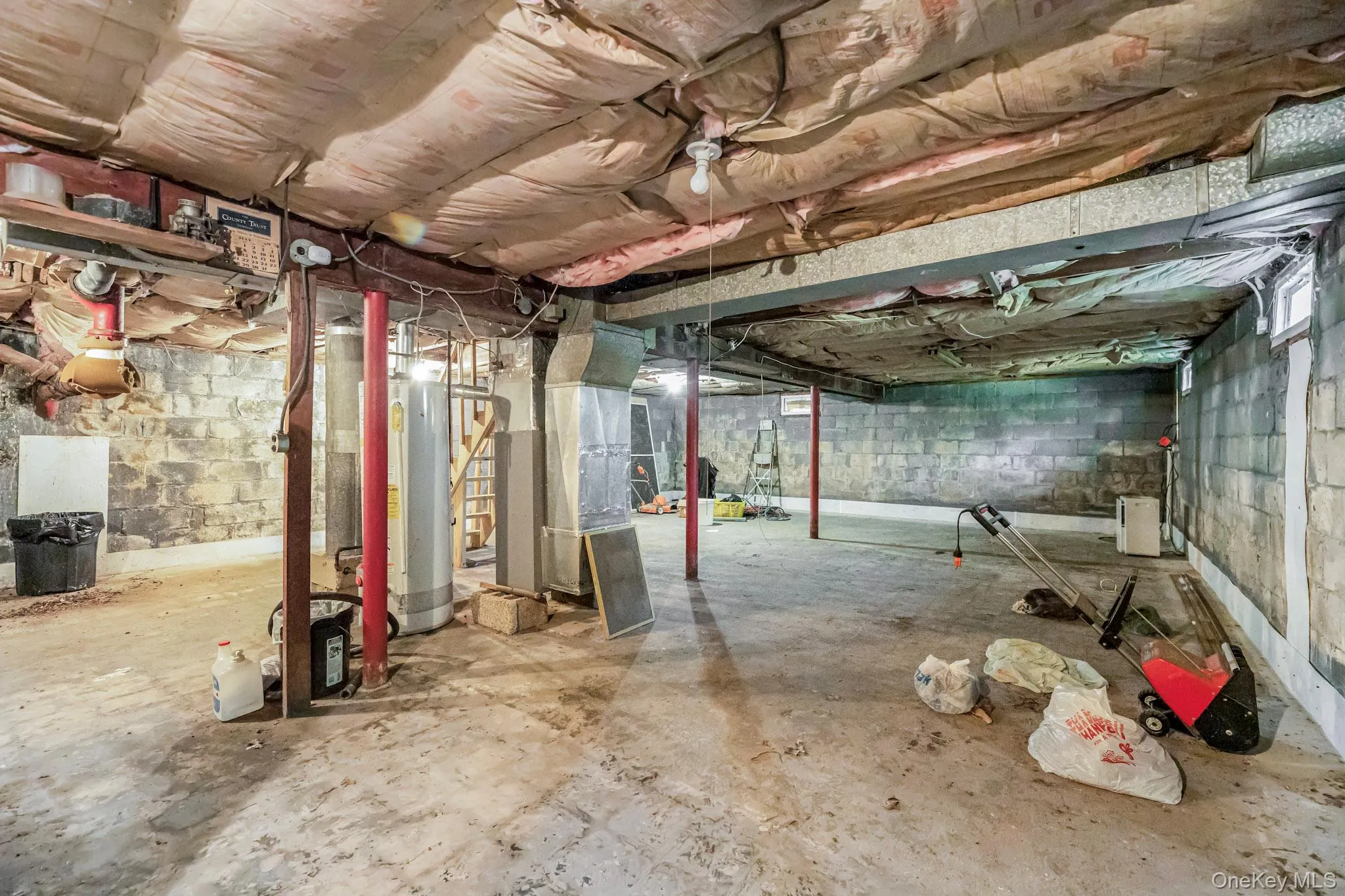 Unfinished below grade area featuring heating unit and gas water heater Unfinished below grade area featuring heating unit and gas water heater