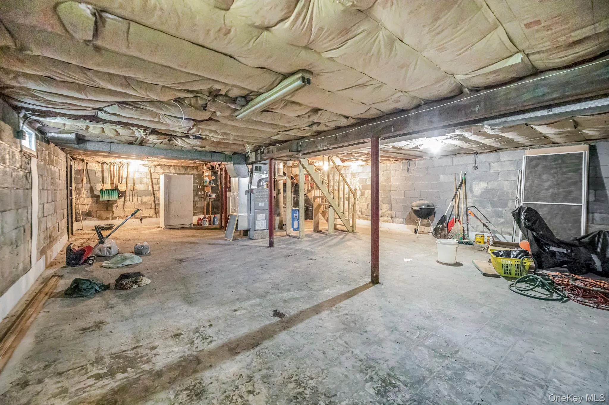 Unfinished basement featuring stairway and heating unit Unfinished basement featuring stairway and heating unit