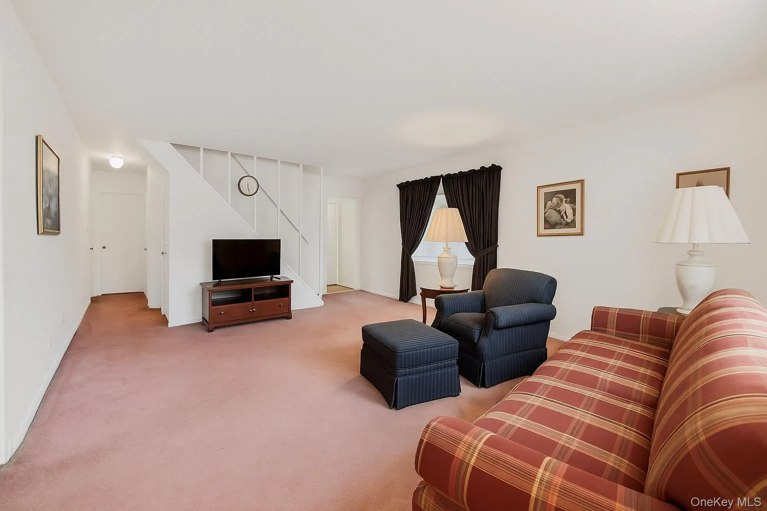 Carpeted living area with baseboards Carpeted living area with baseboards