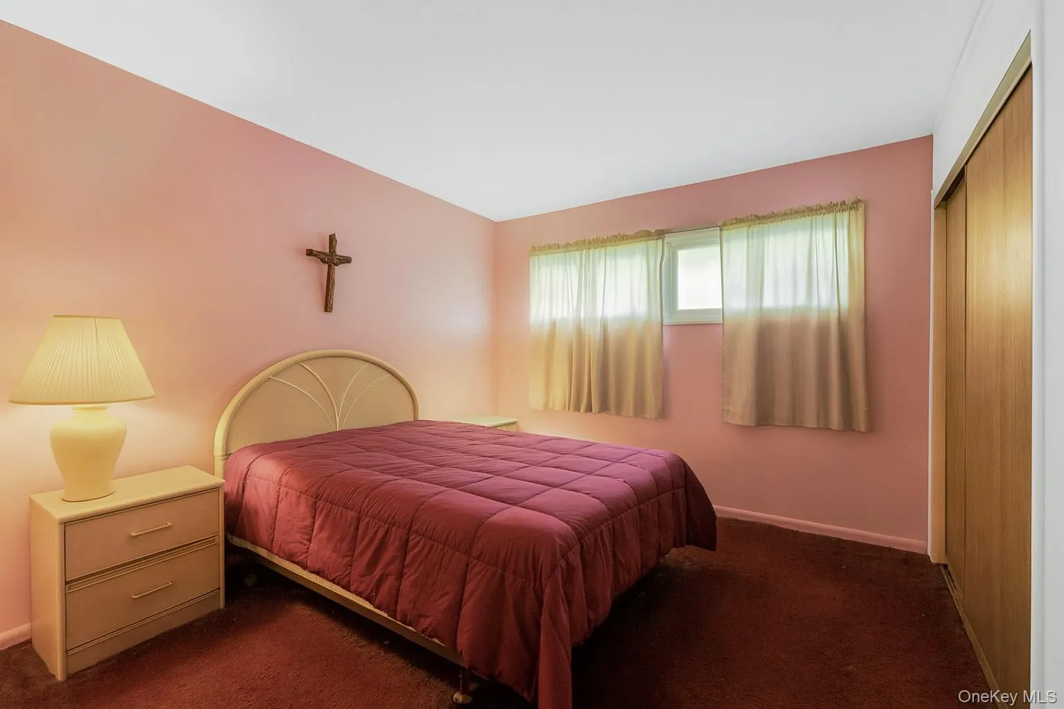 Carpeted bedroom with baseboards and a closet Carpeted bedroom with baseboards and a closet