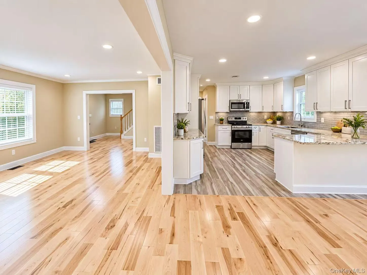 Kitchen featuring white cabinetry, stainless steel appliances, and granite countertops Kitchen featuring white cabinetry, stainless steel appliances, and granite countertops