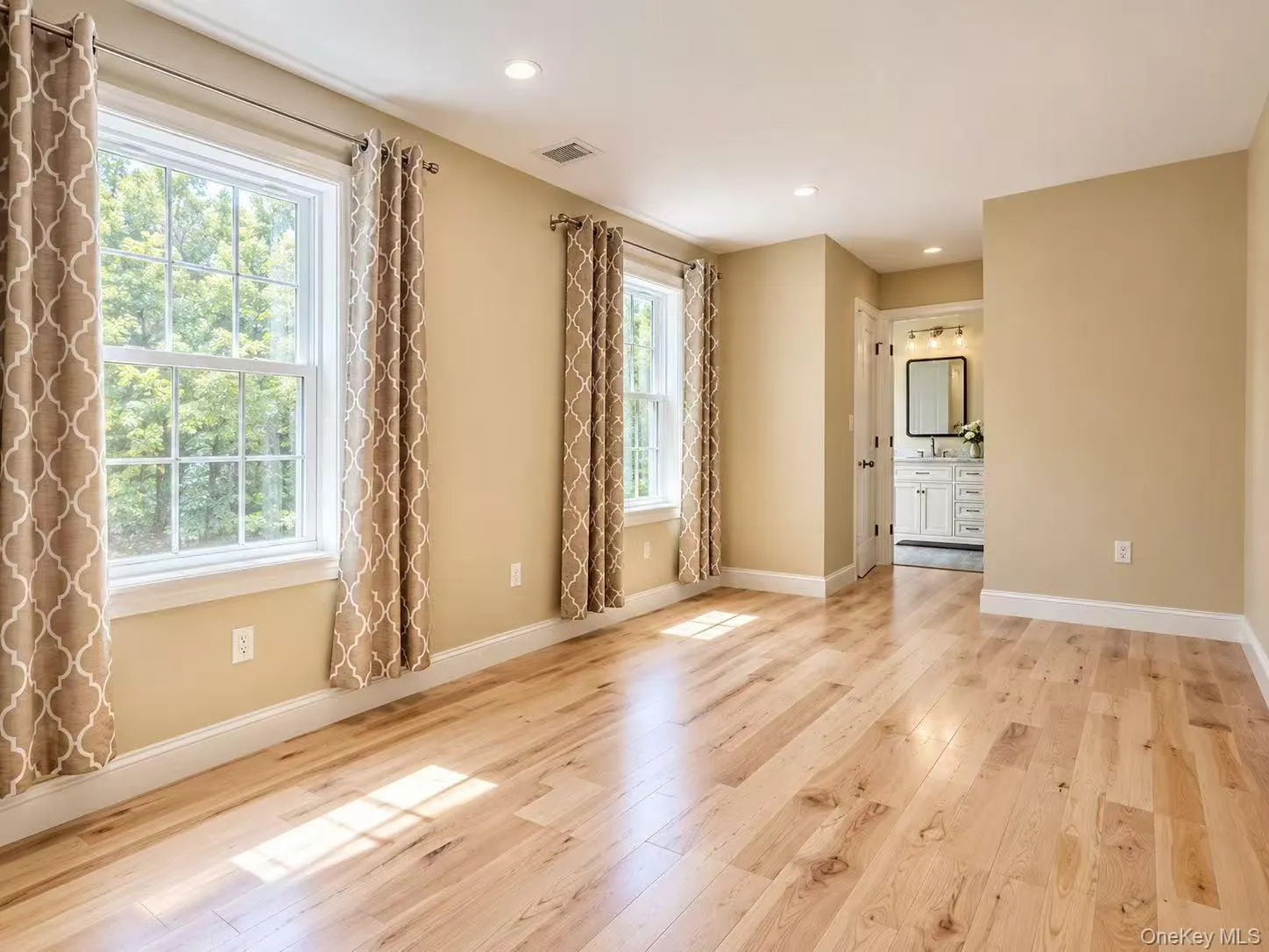 Light wood-finish flooring, recessed lighting, and two double-hung windows Light wood-finish flooring, recessed lighting, and two double-hung windows