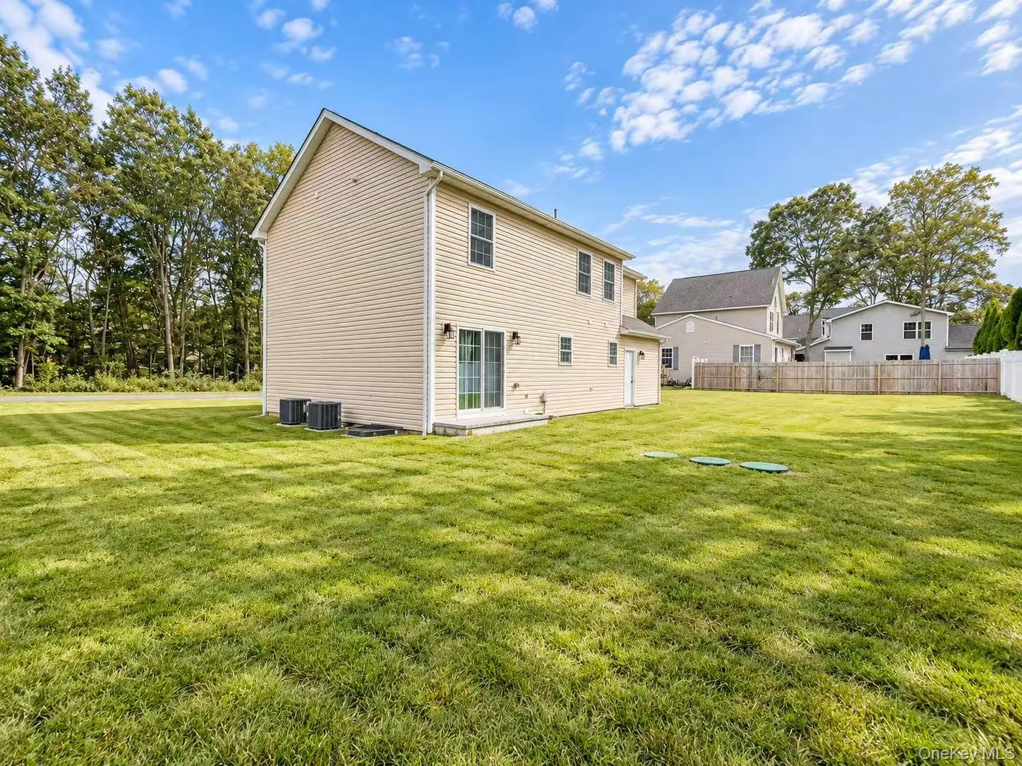 Expansive grassy yard surrounding a property with beige siding Expansive grassy yard surrounding a property with beige siding