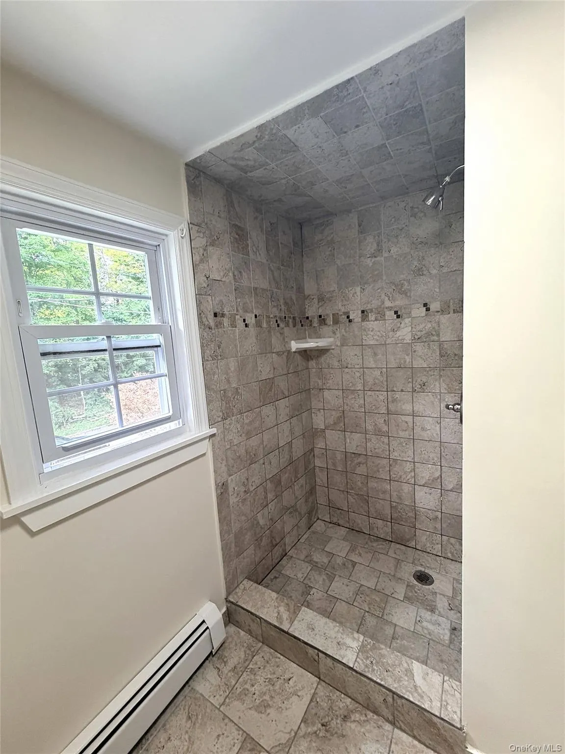 The updated bathroom features this full tiled shower. The updated bathroom features this full tiled shower.